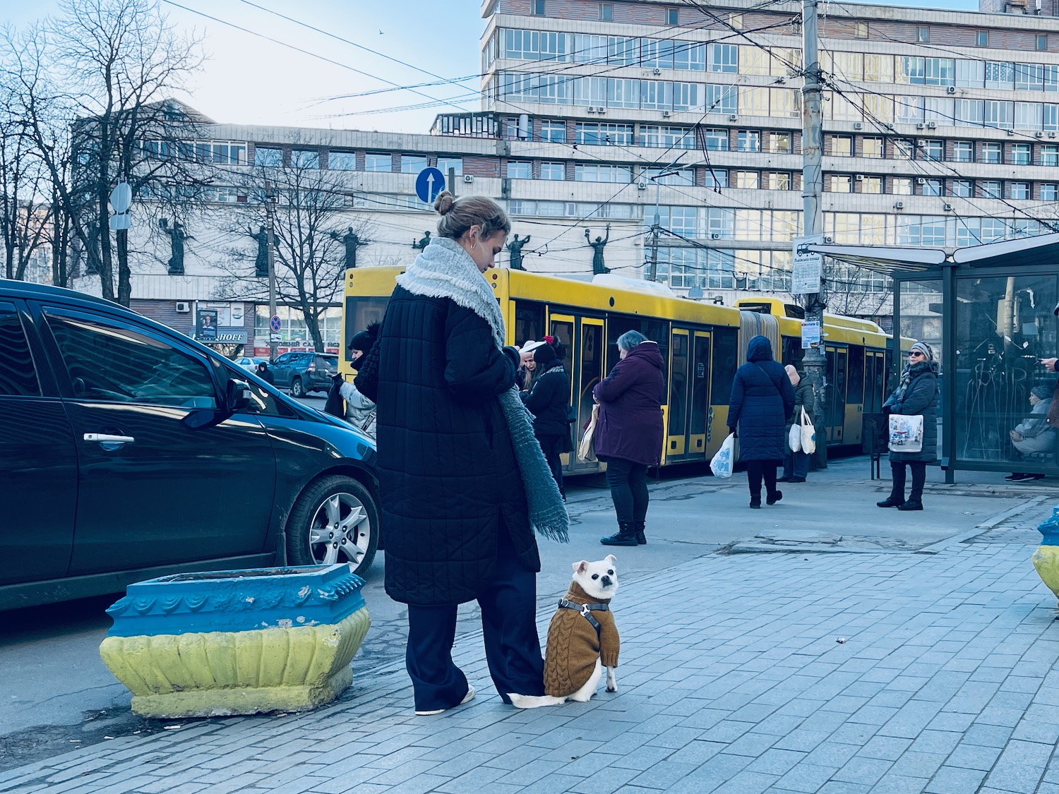 a woman standing next to a dog