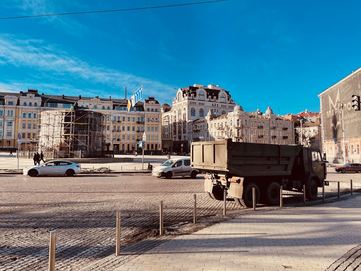 a truck parked on a brick road next to a building