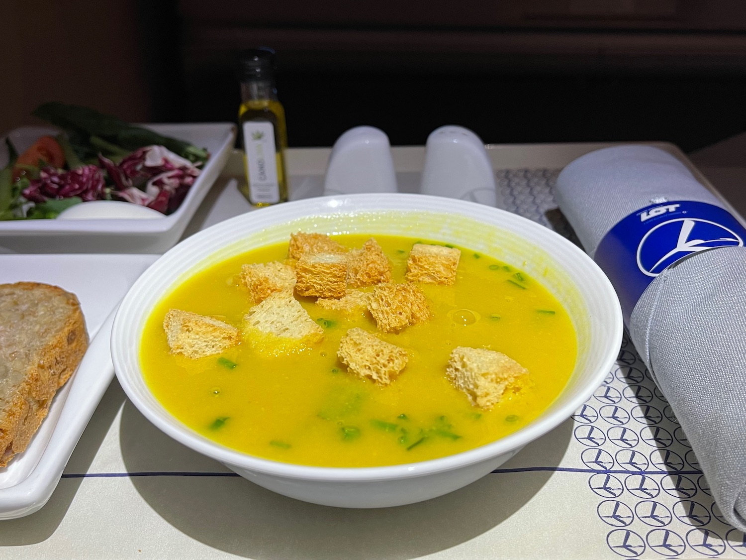 a bowl of soup with croutons on a table