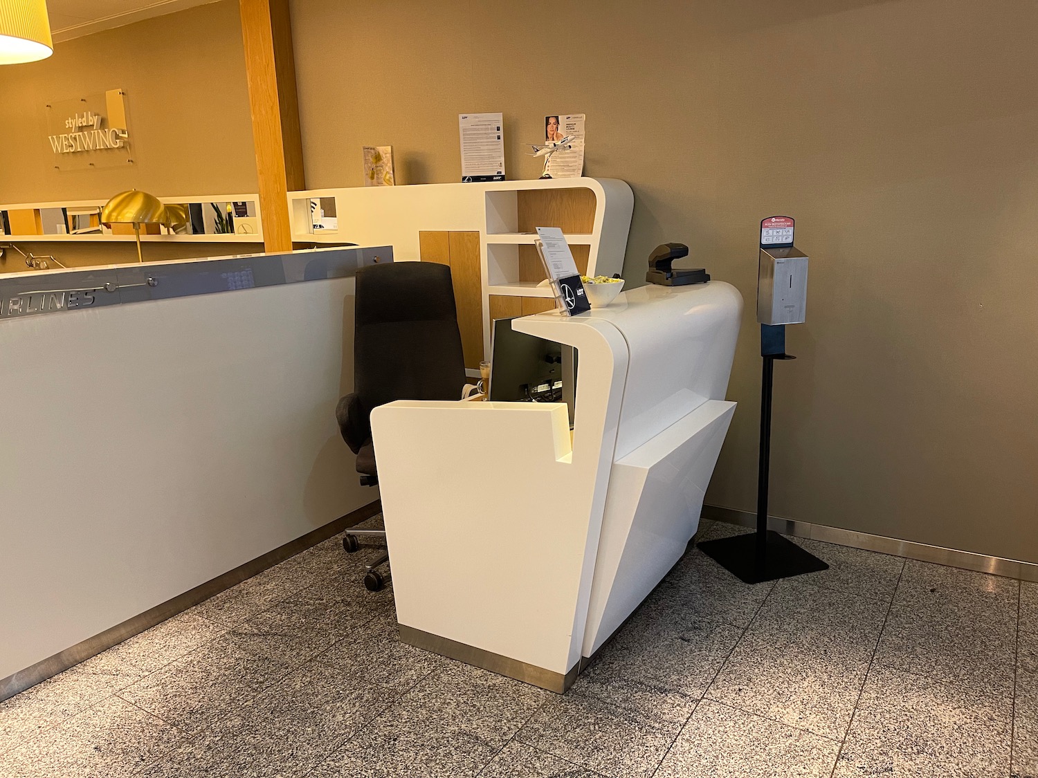 a white desk with a black chair in front of a counter