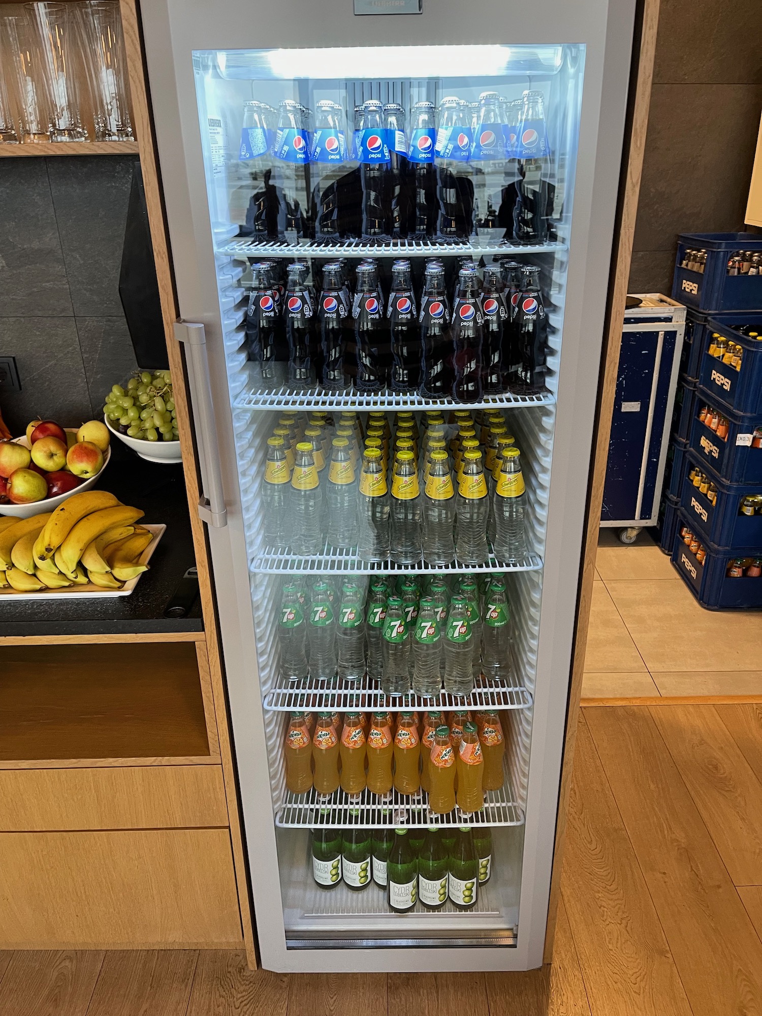 a refrigerator full of soda bottles and fruit