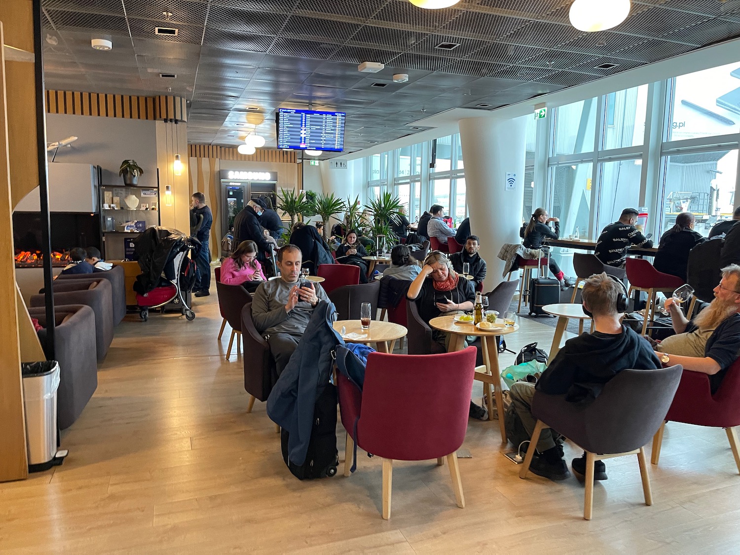 a group of people sitting at tables in a room with large windows