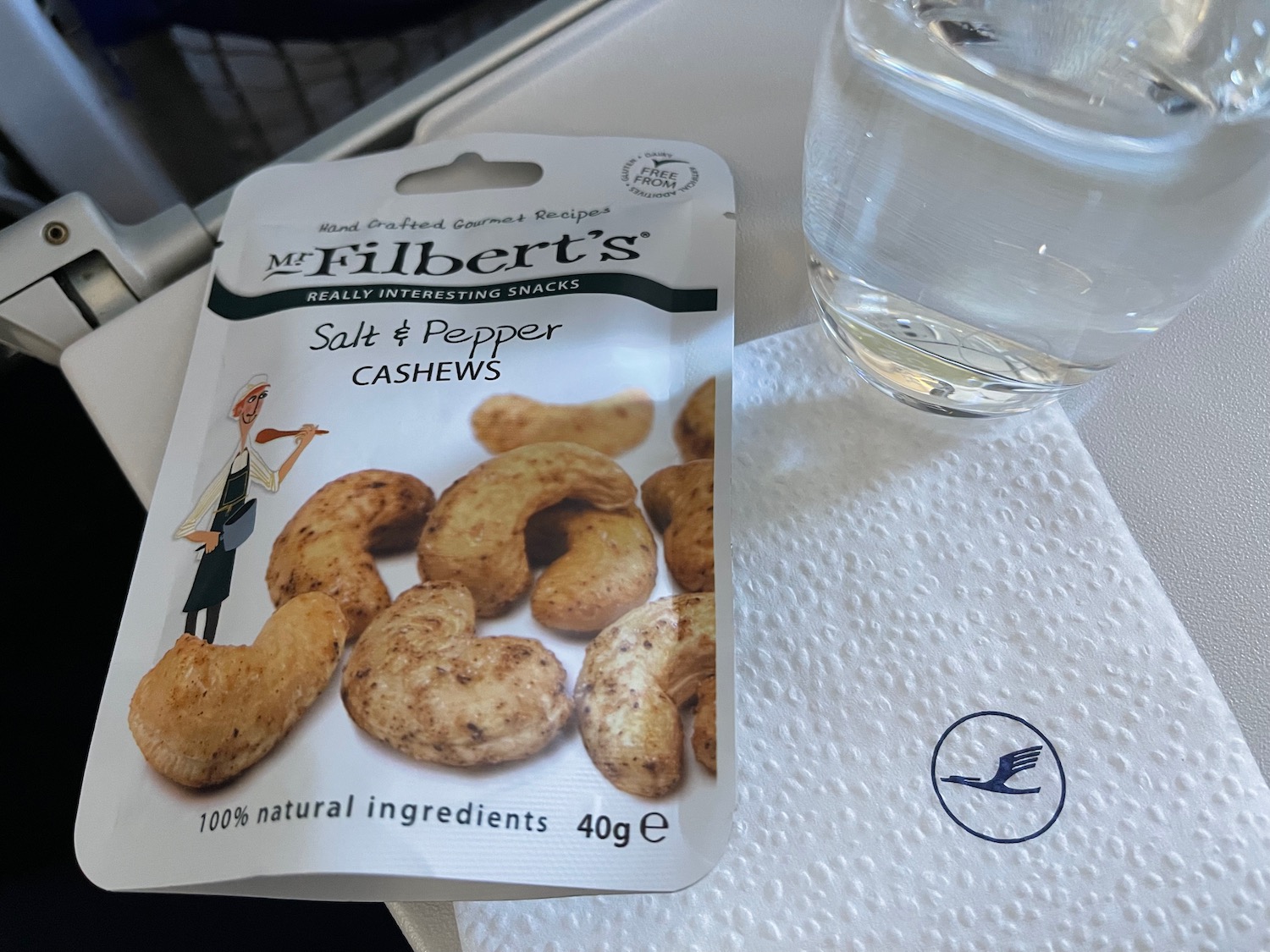 a package of salt and pepper cashews next to a glass of water