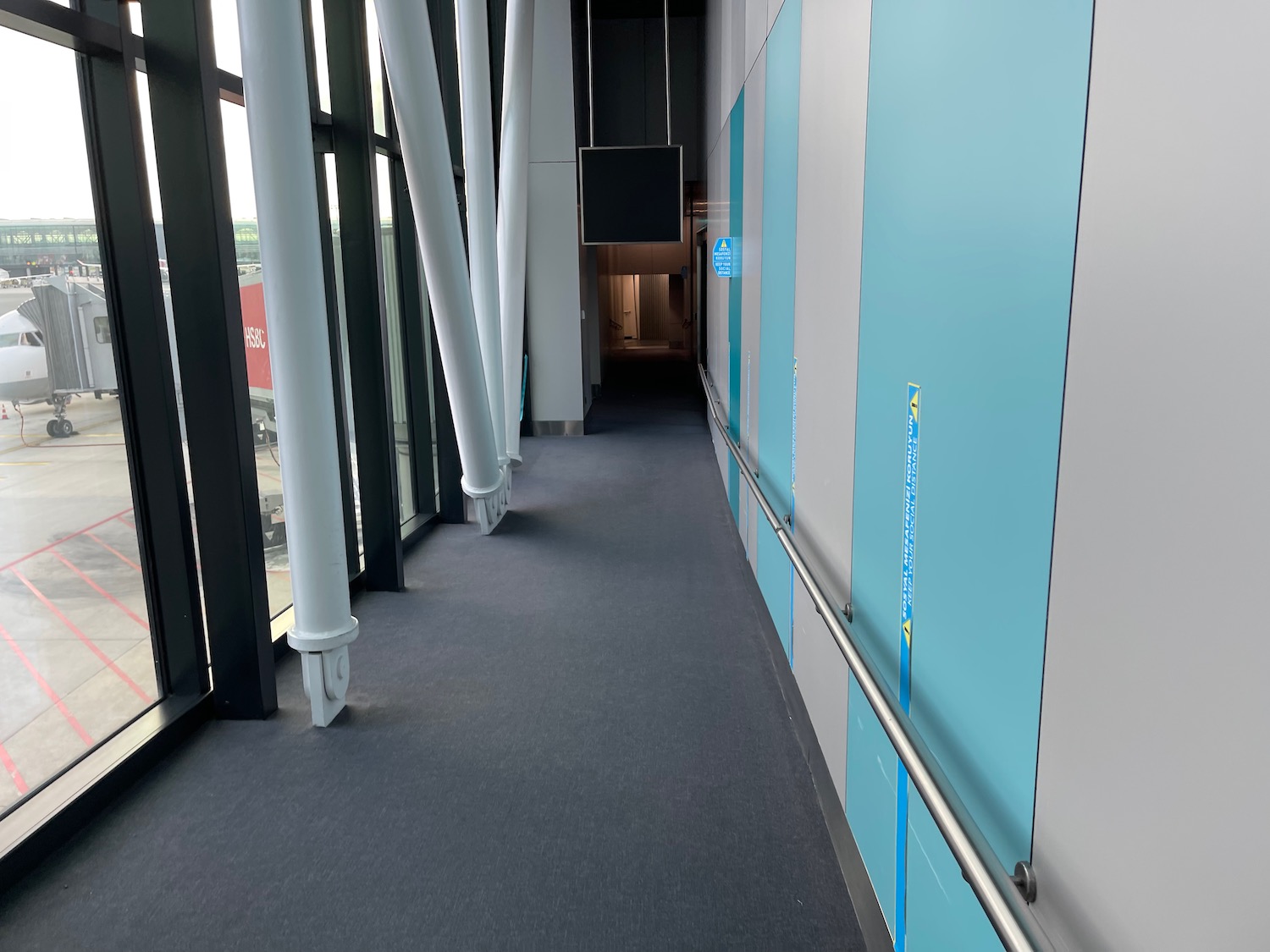 a hallway with a metal railing and a television