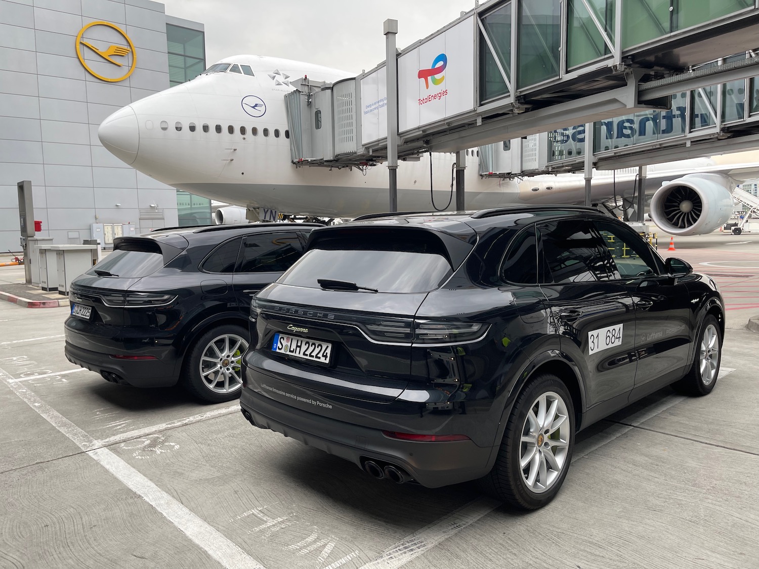 a black suvs parked in front of a plane