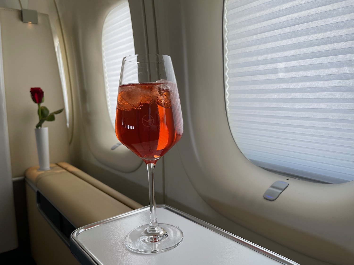 a glass of red liquid on a table in a plane