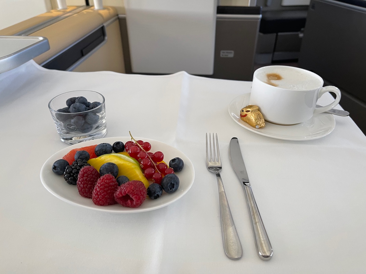 a plate of fruit and a cup of coffee on a table