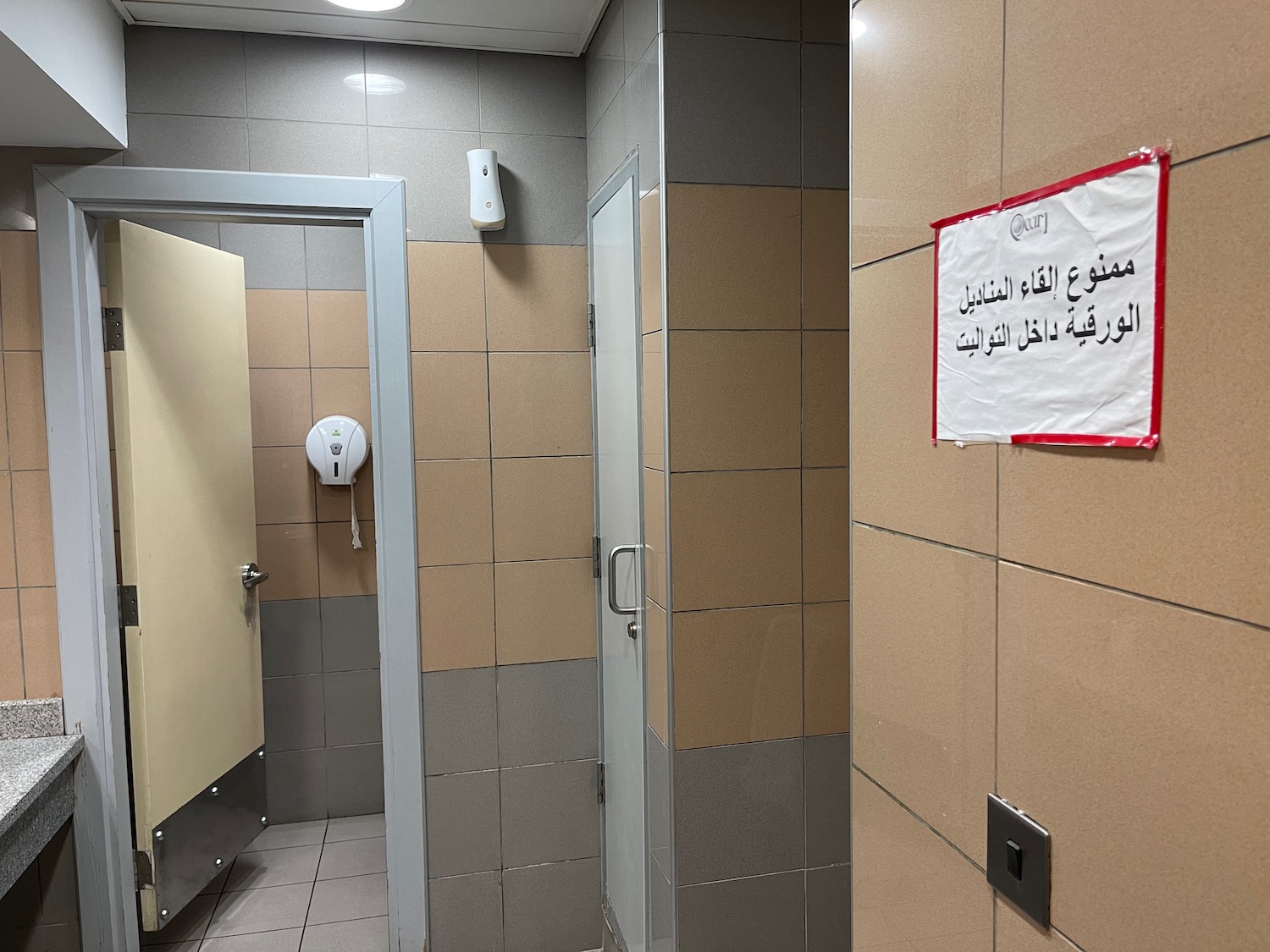 a bathroom with a white sign on the wall