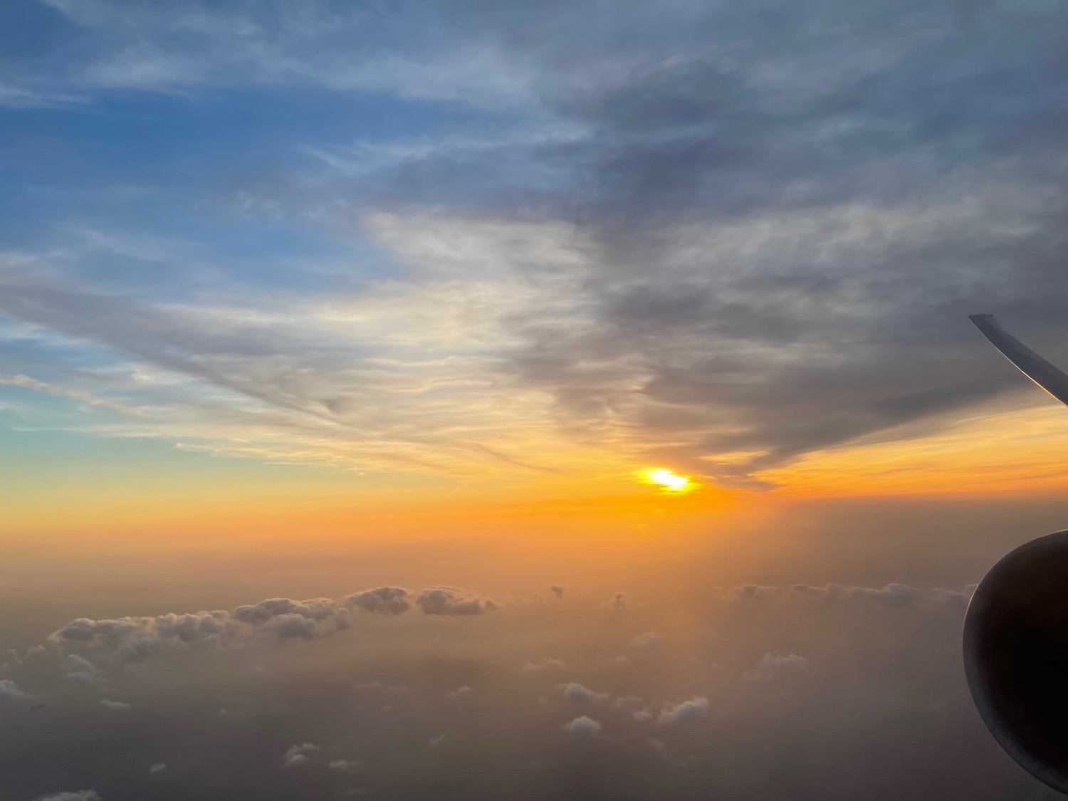 a sunset over clouds and a blue sky