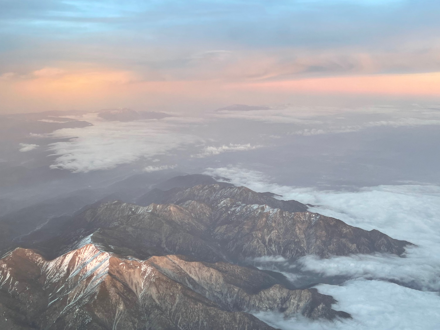 a mountain range with clouds and a sunset