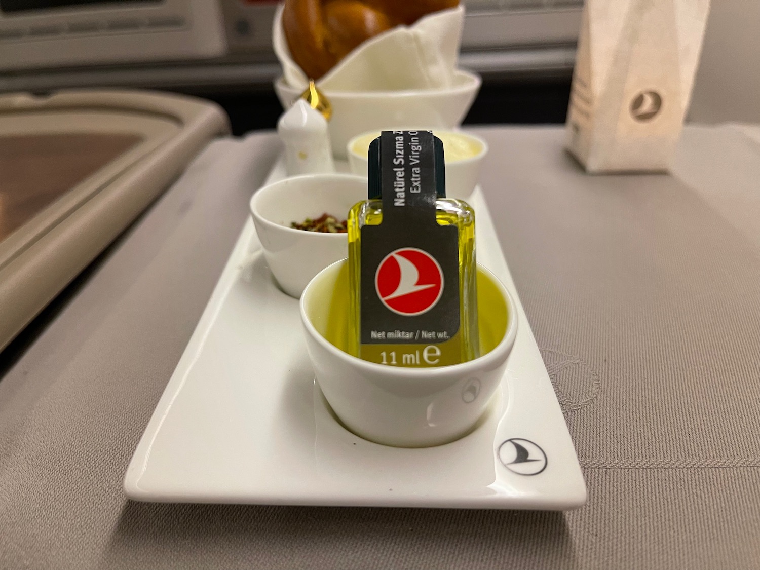 a small bottle of oil in a small white bowl on a tray