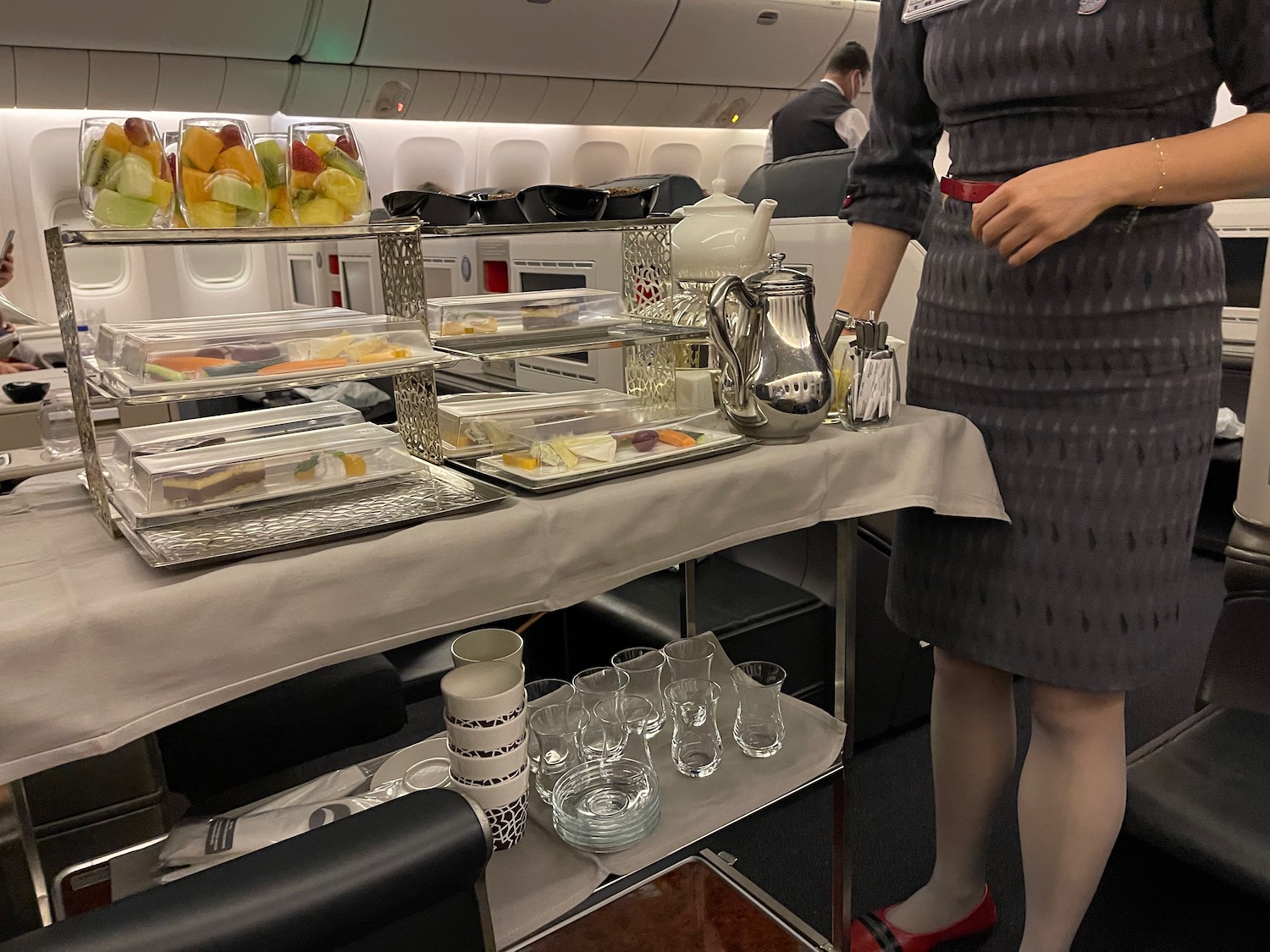 a woman standing in an airplane with trays of food