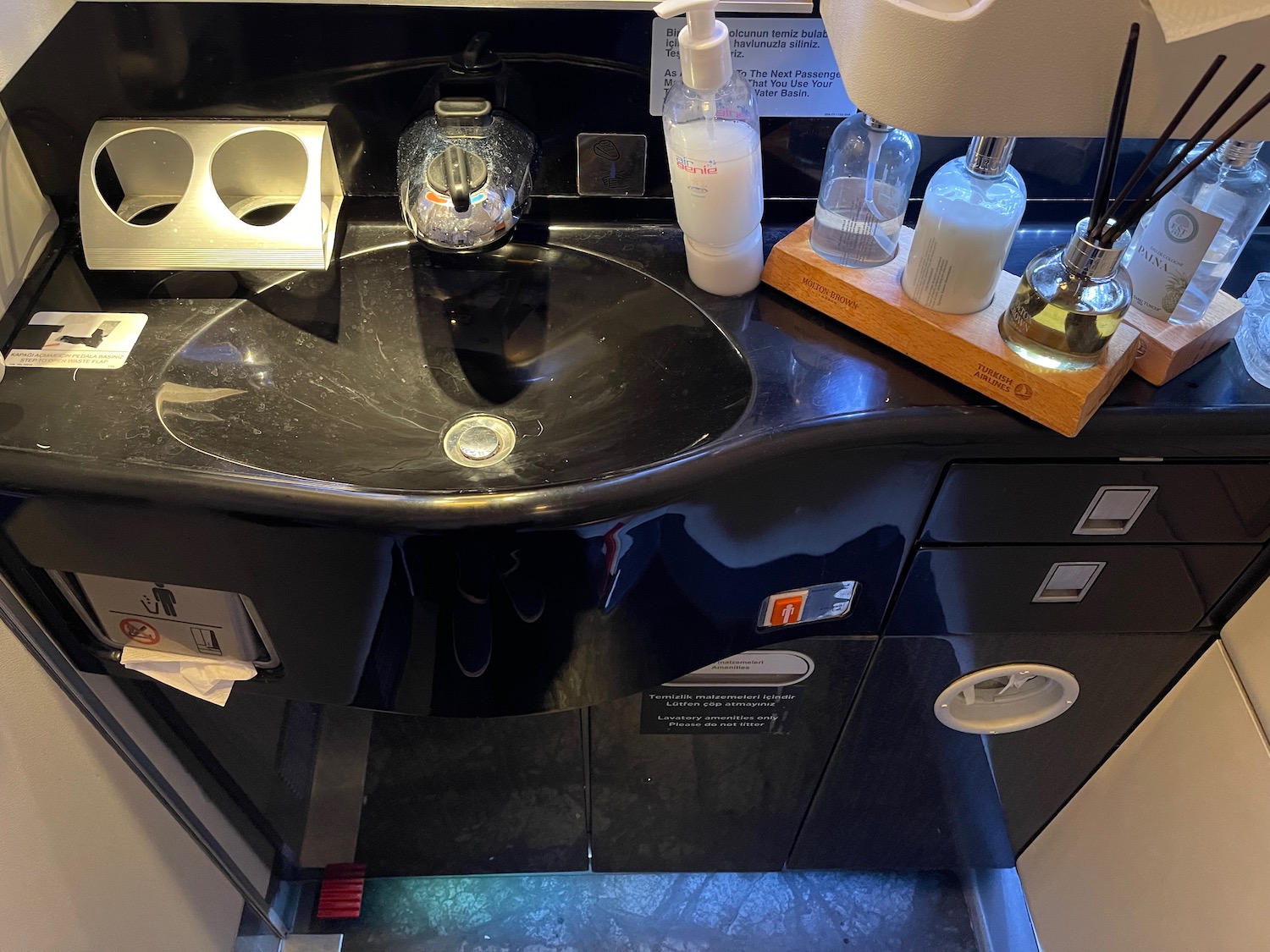 a sink with soap bottles and soap dispenser