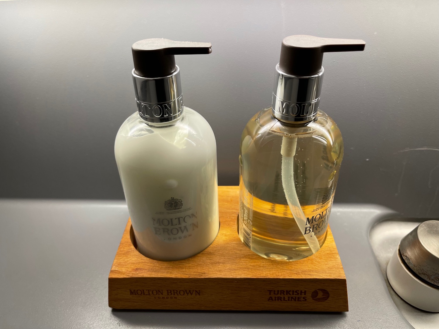 a couple of soap dispensers on a wooden stand