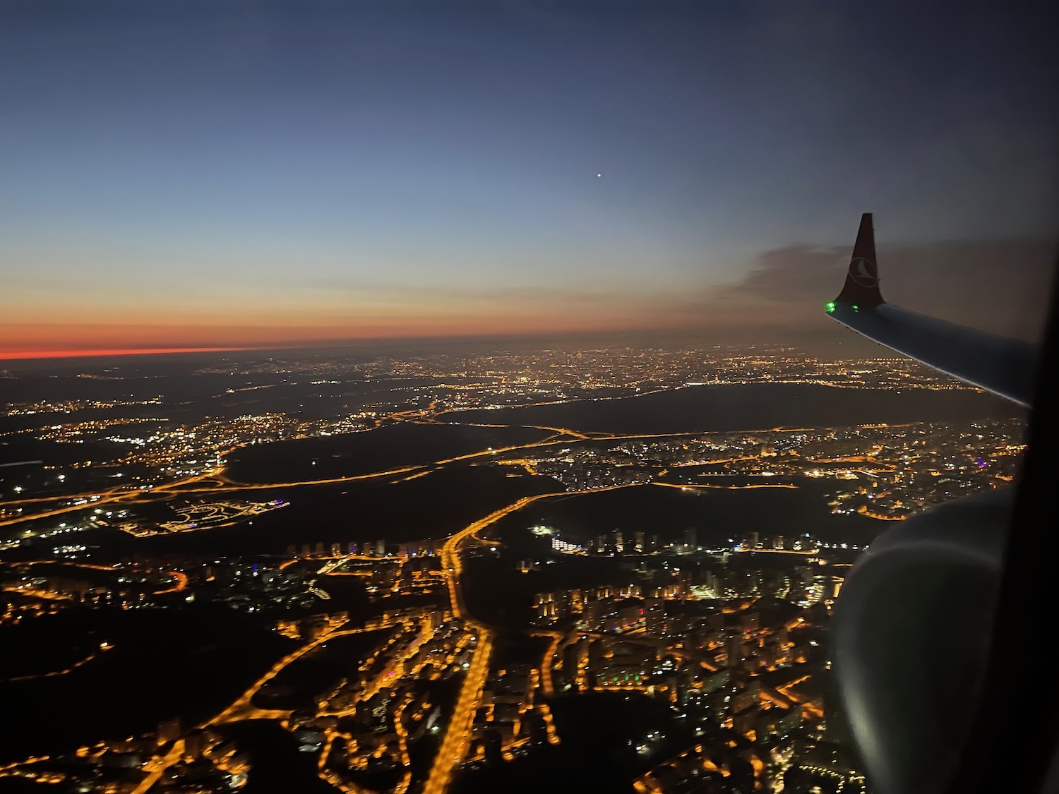 an airplane wing and a city at night