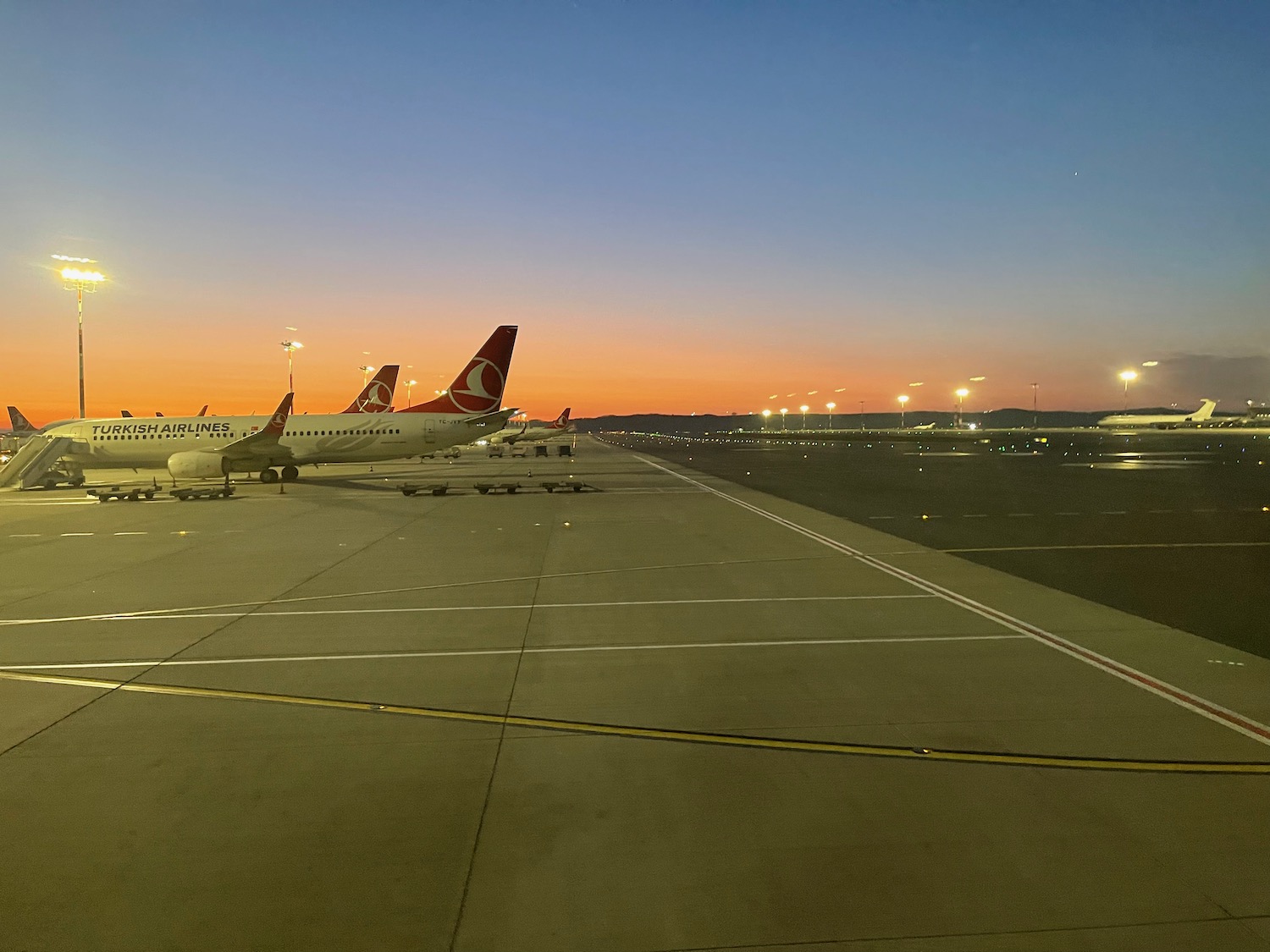 airplanes on a runway at sunset