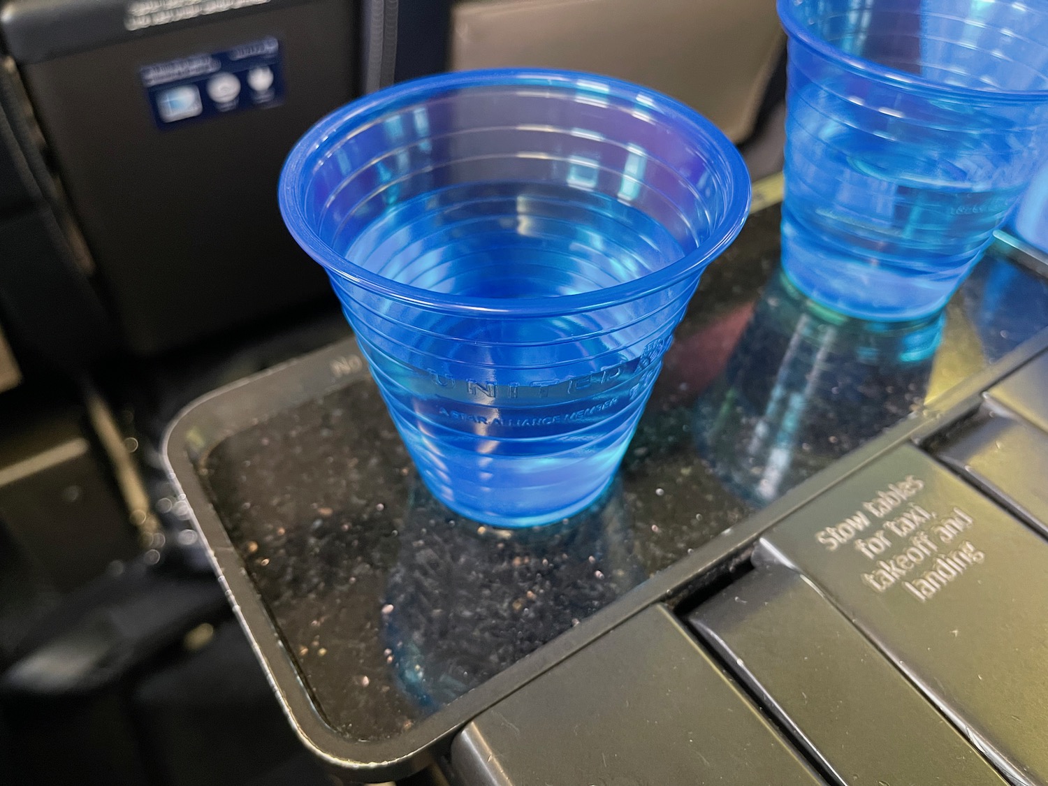 a pair of blue plastic cups on a tray