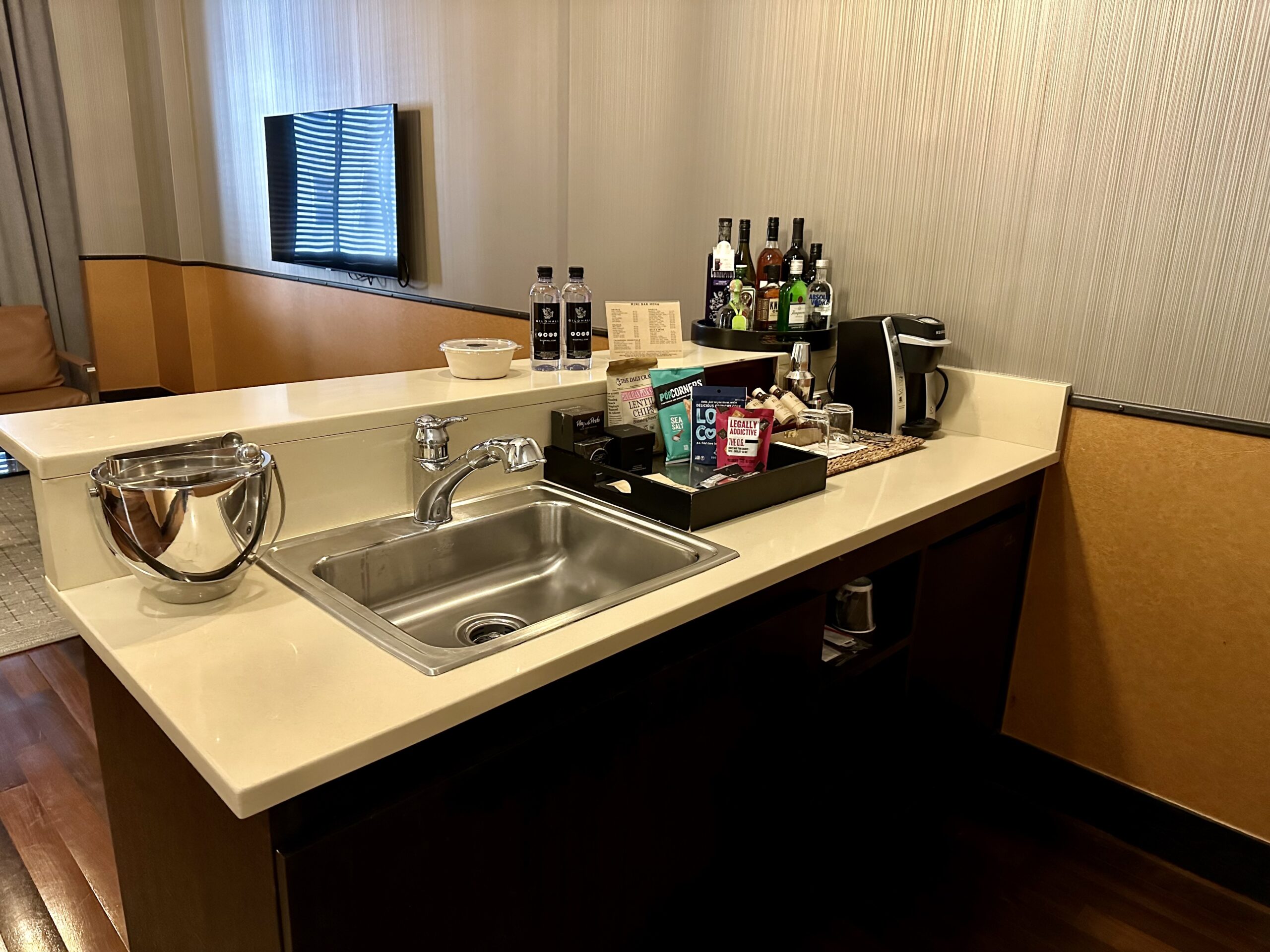 a sink and a tray of liquor on a counter