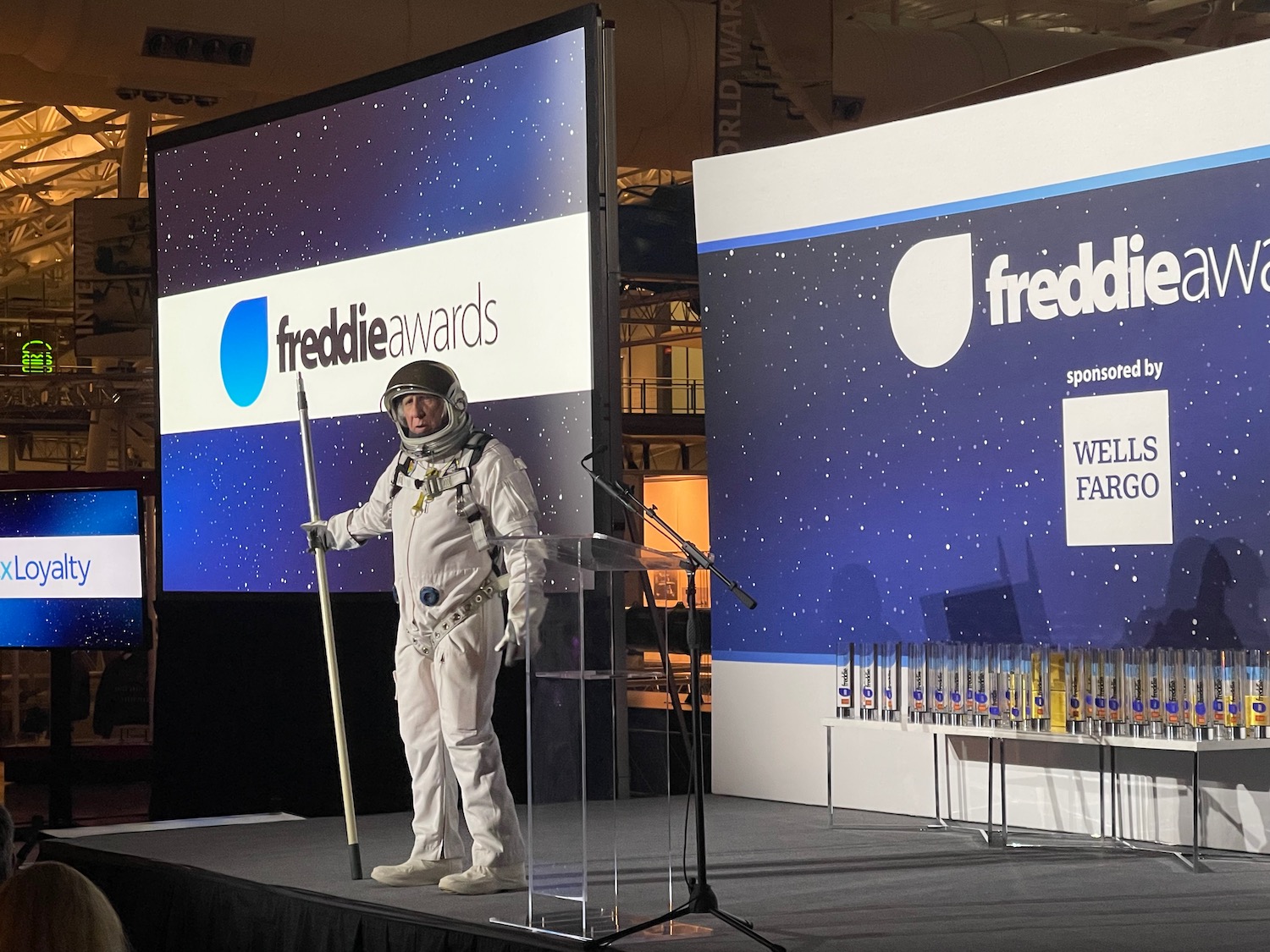 a man in a space suit standing on a podium