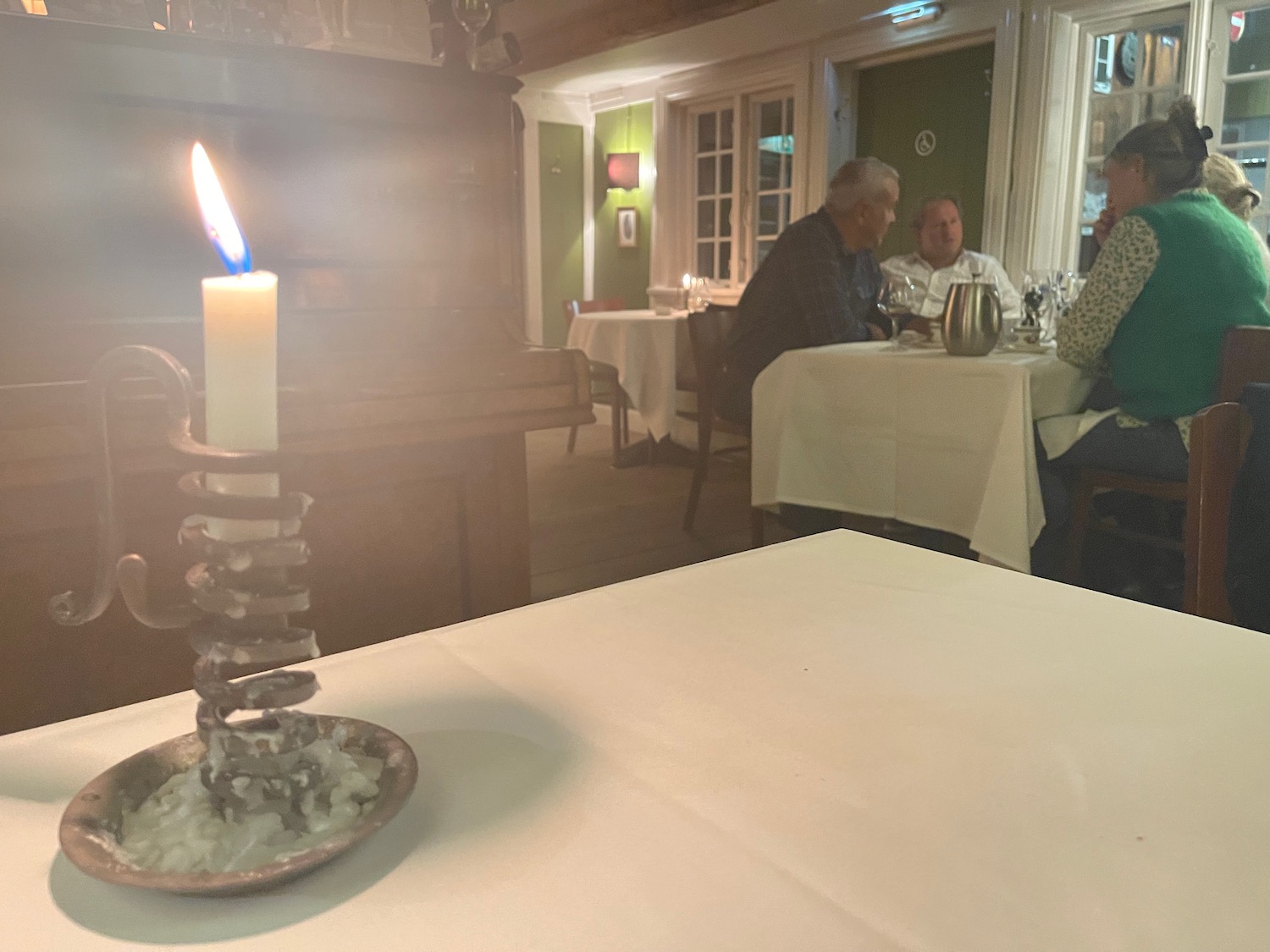 a group of people sitting at a table with a candle