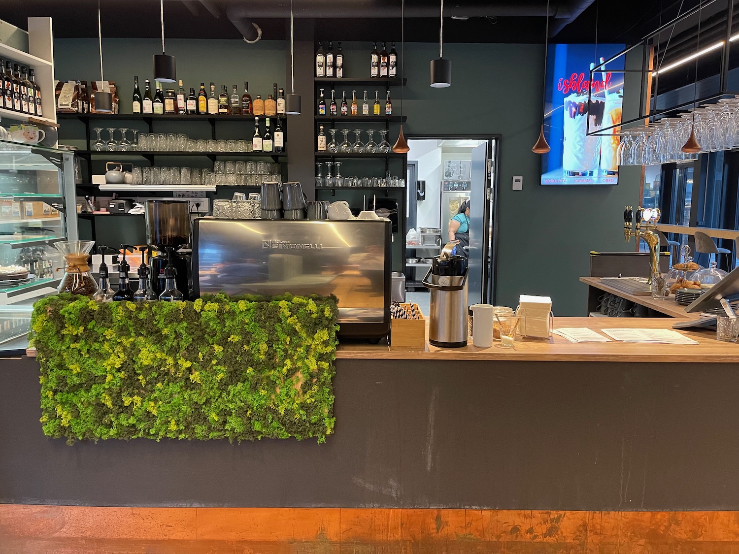 a bar with a counter and shelves of wine