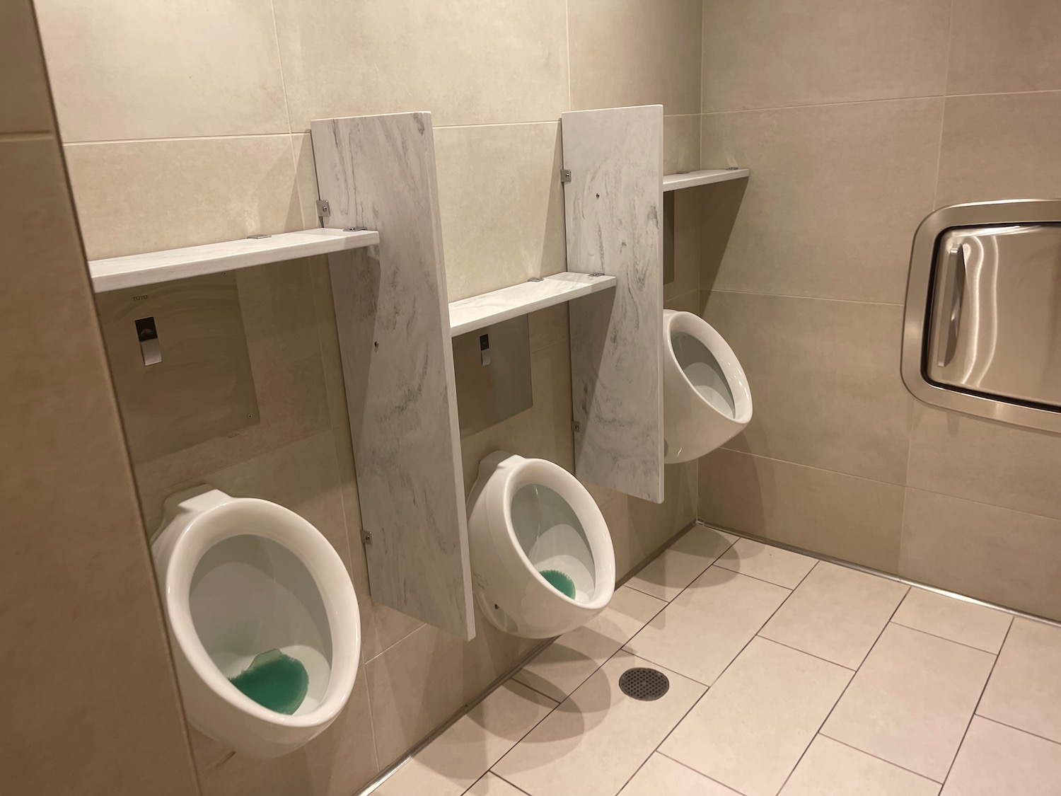 a row of urinals in a public bathroom