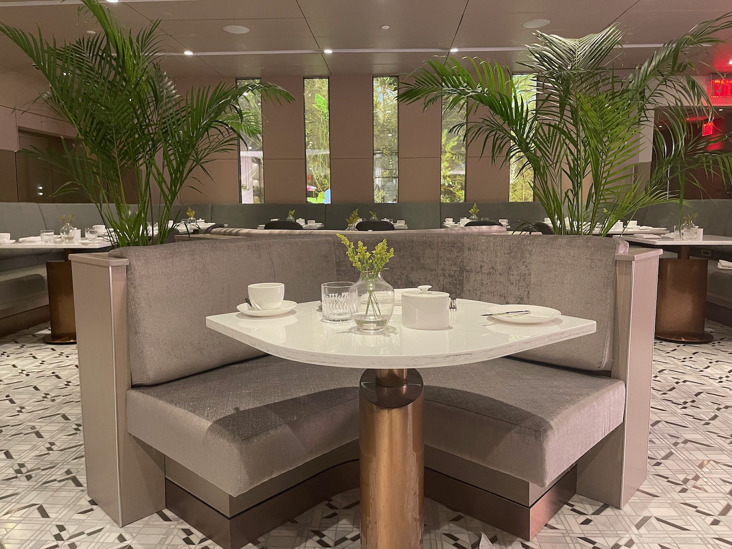 a table with a white table and two tables with plants in the background