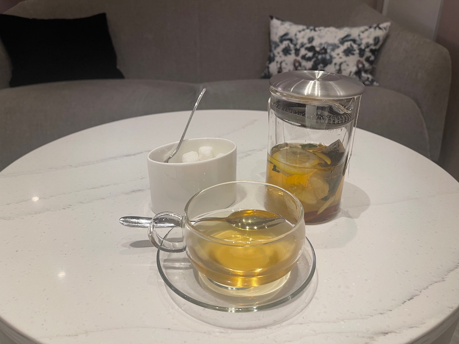 a cup and saucer with a teapot and a spoon on a table