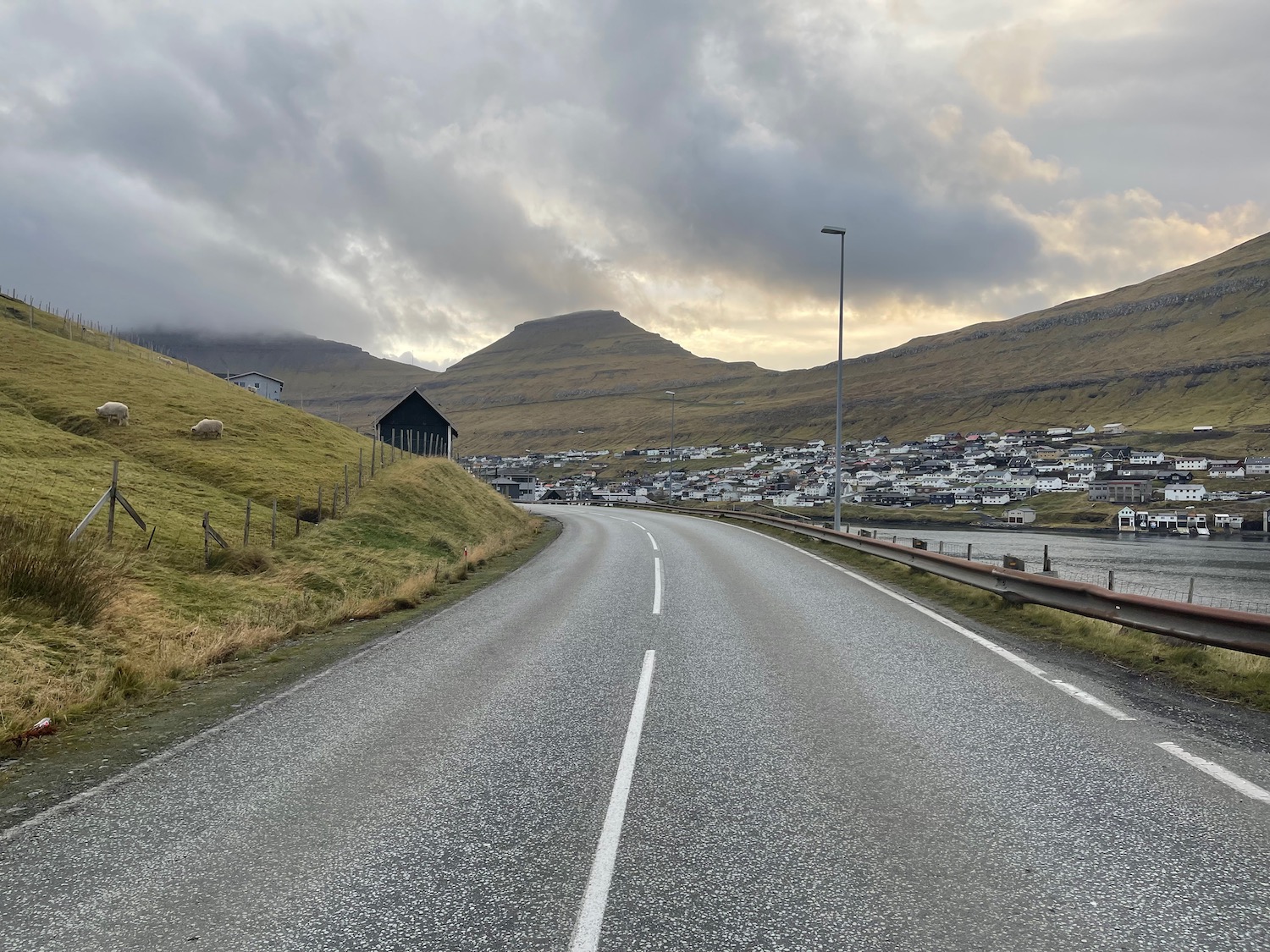 a road with a small town in the distance