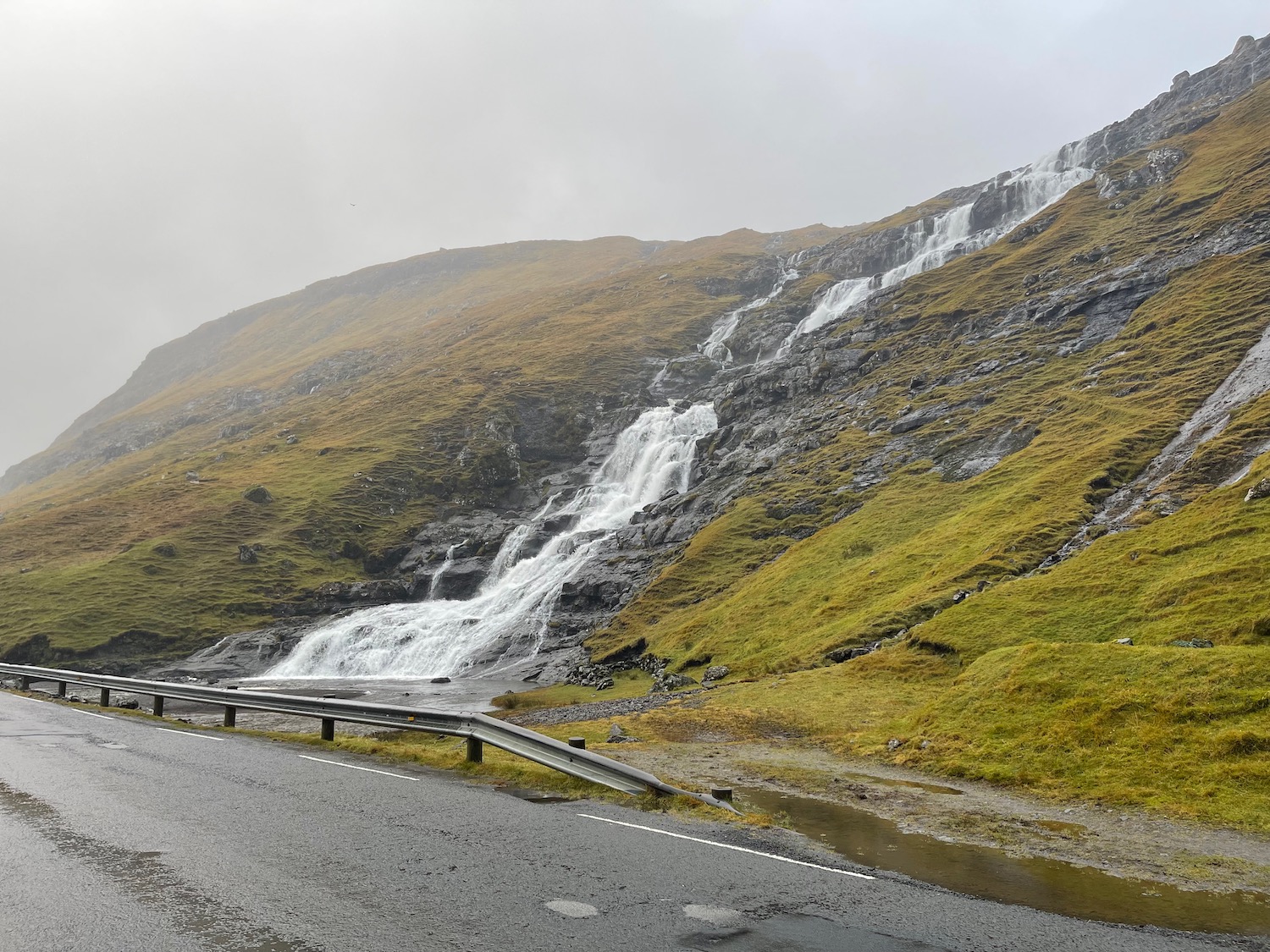 a road with a waterfall on the side