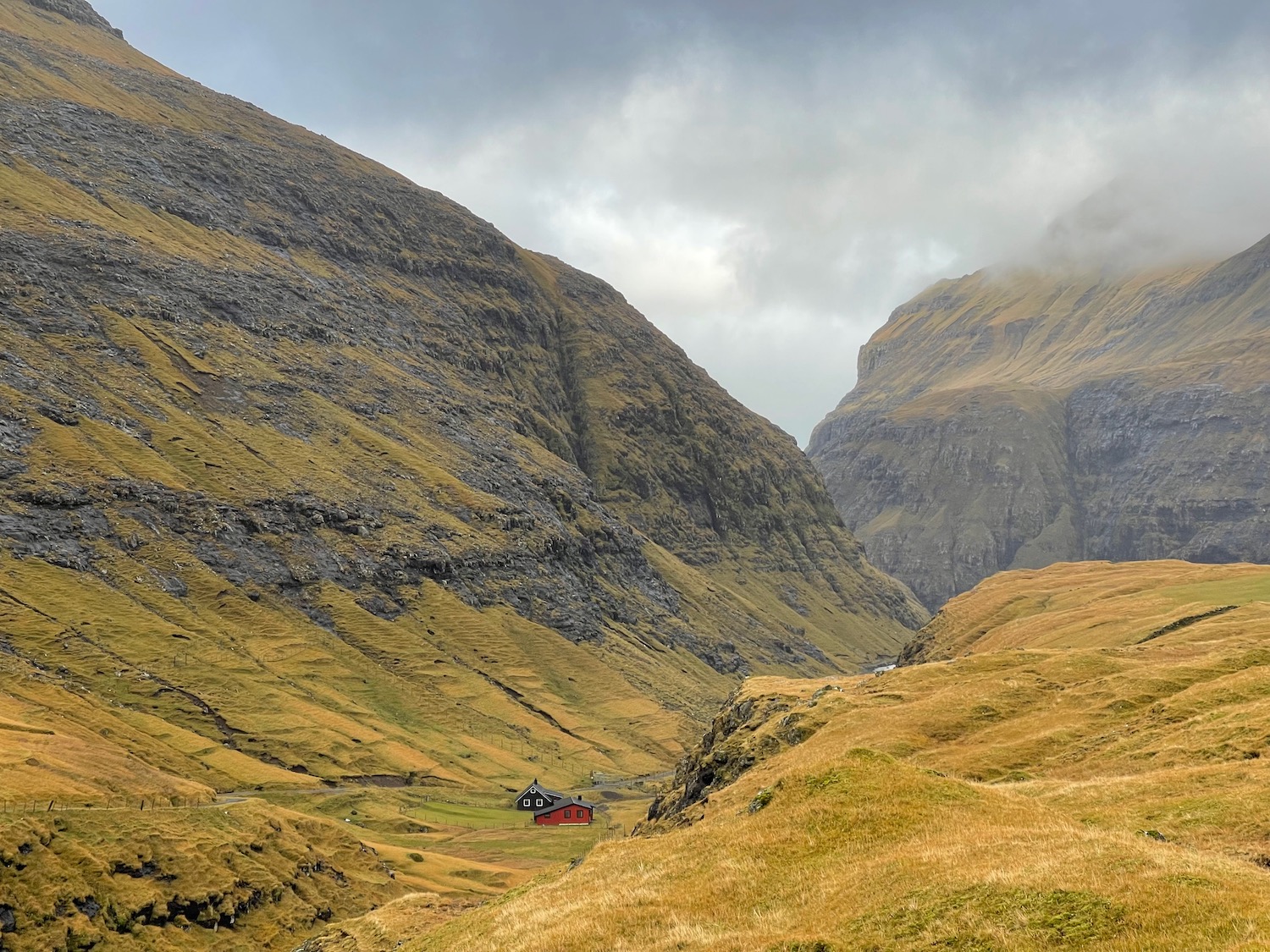 a house in a valley with mountains