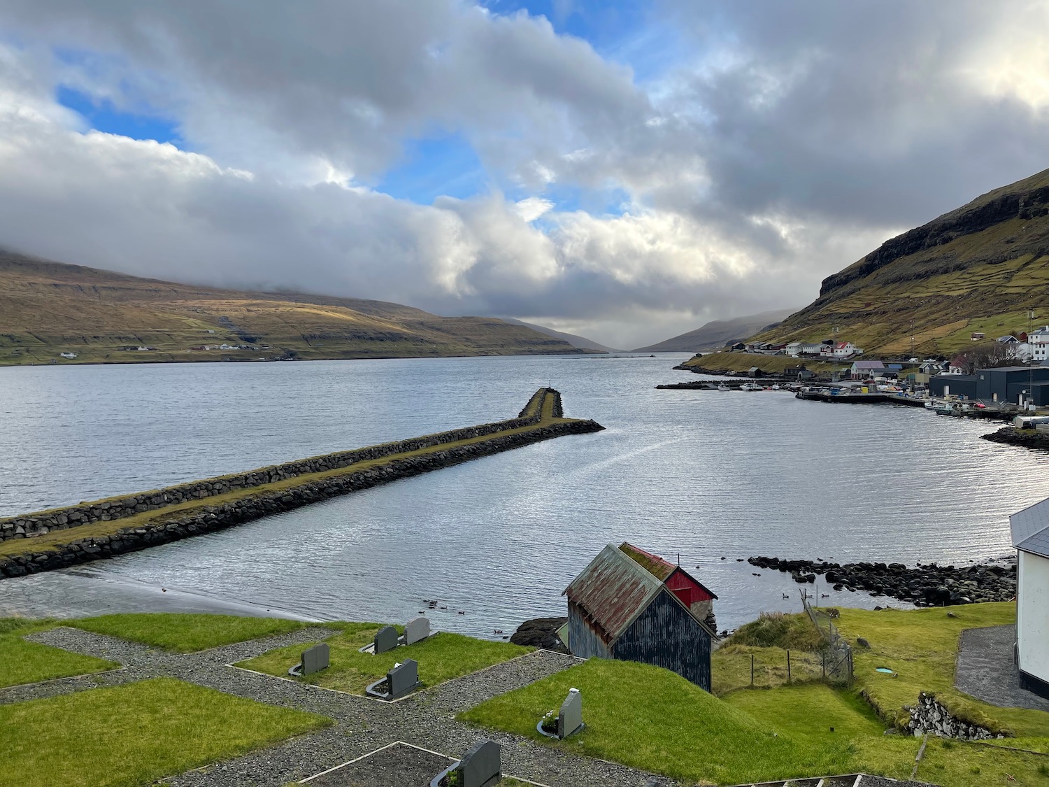 a body of water with a stone wall and a building on it