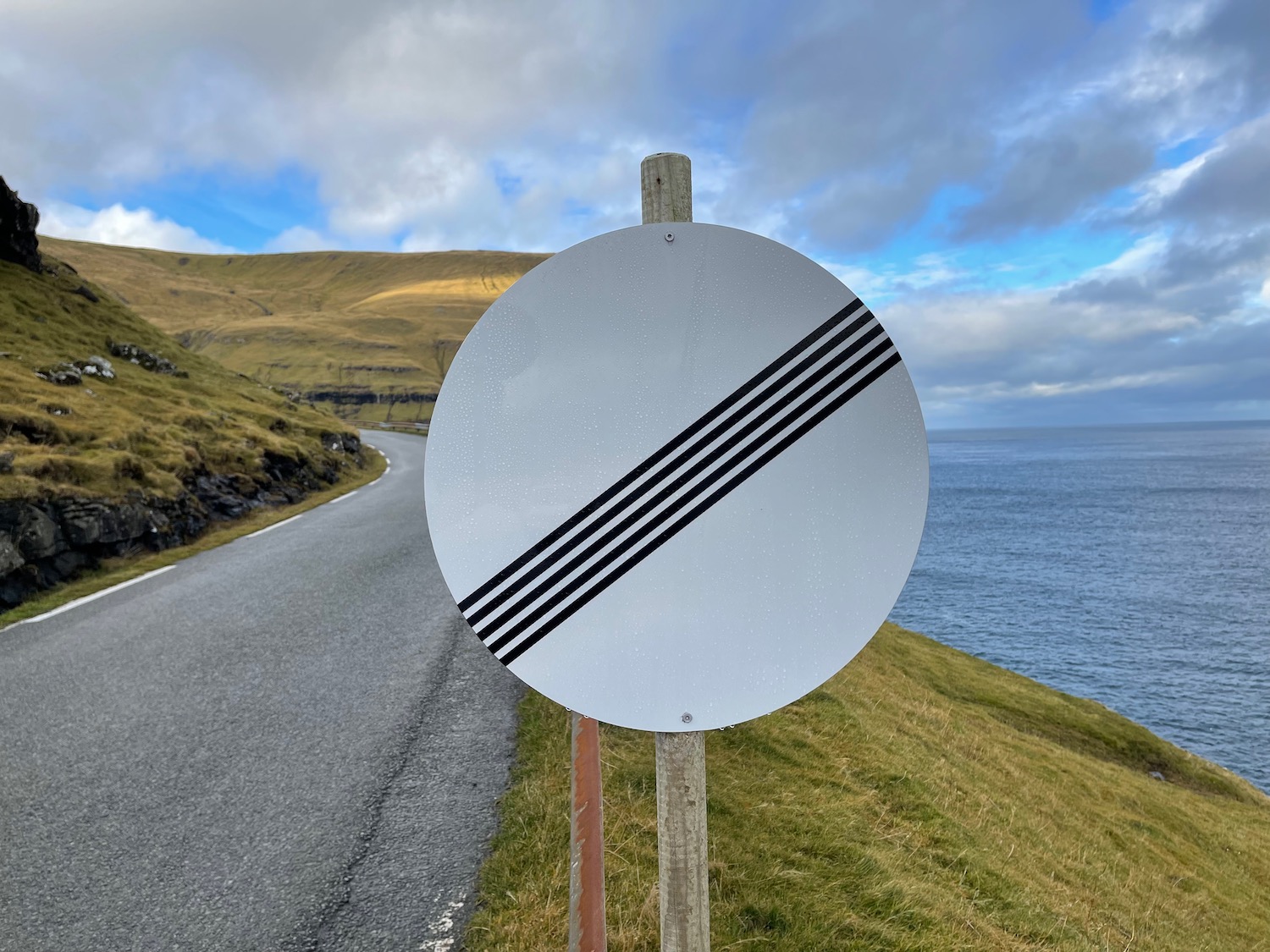 a road sign on a hill by the water