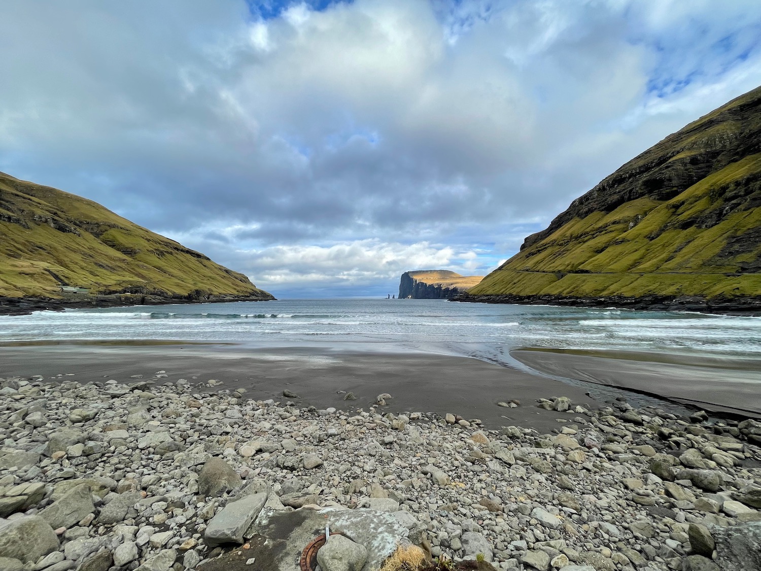 a rocky beach with a body of water and hills