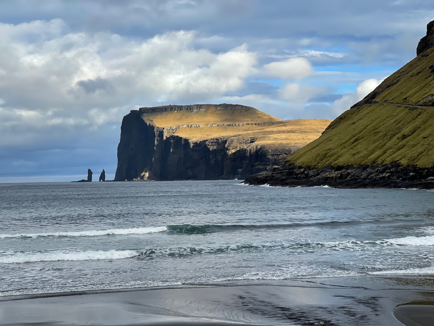 a beach with a cliff and water