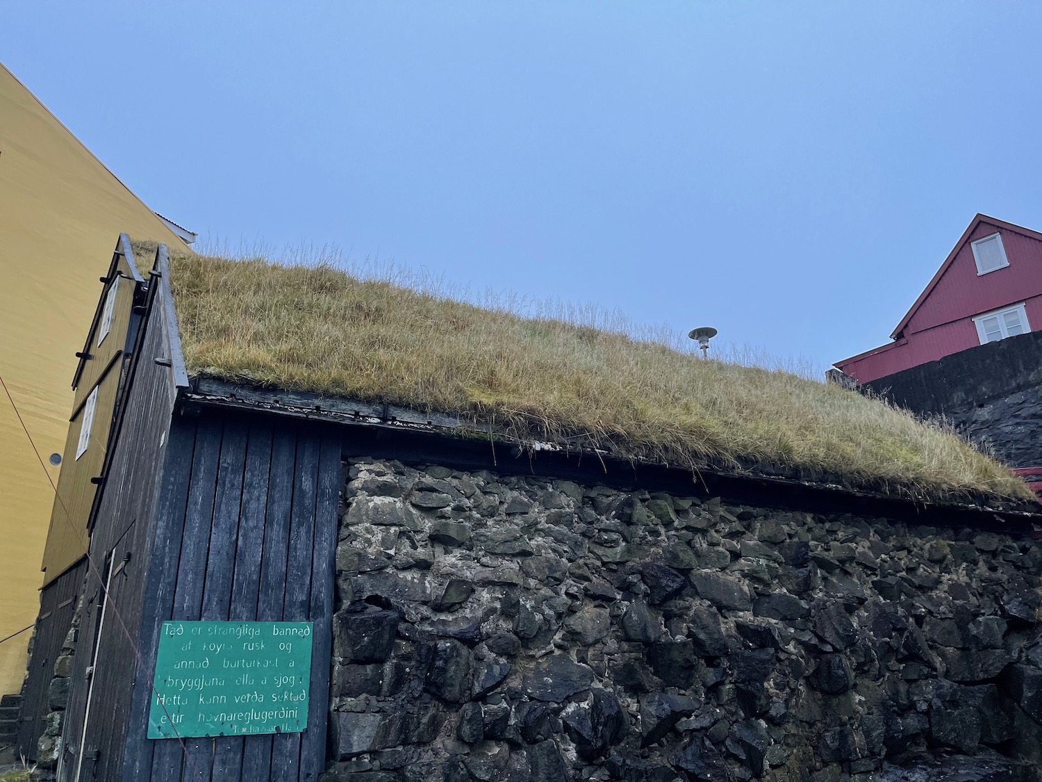 a stone wall with grass on the roof