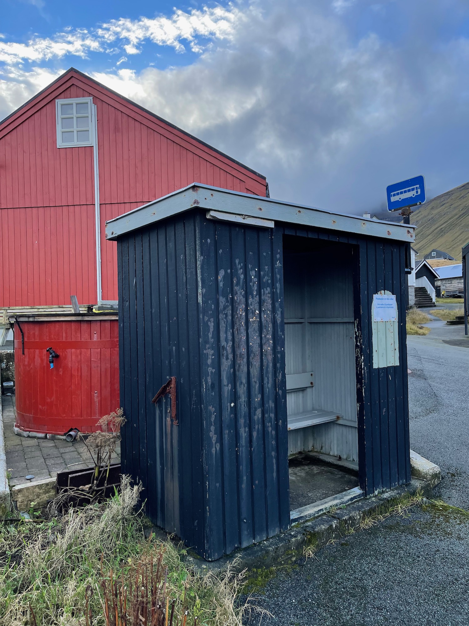 a small blue shed next to a red building