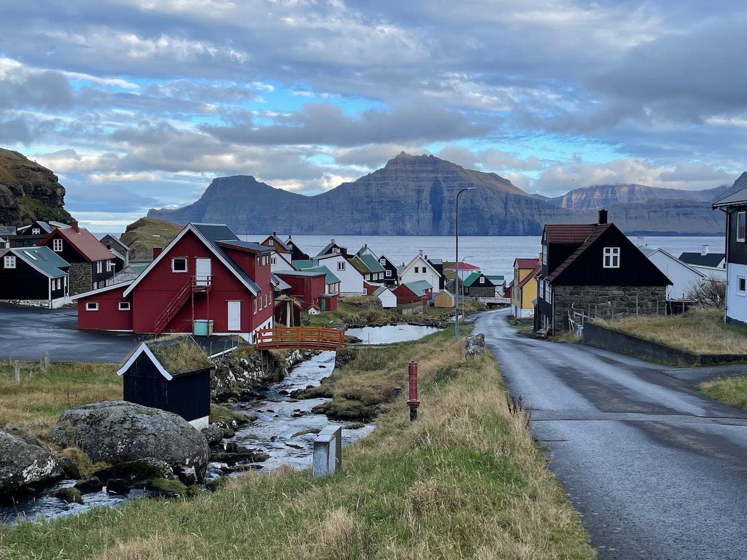 a road with houses and mountains in the background