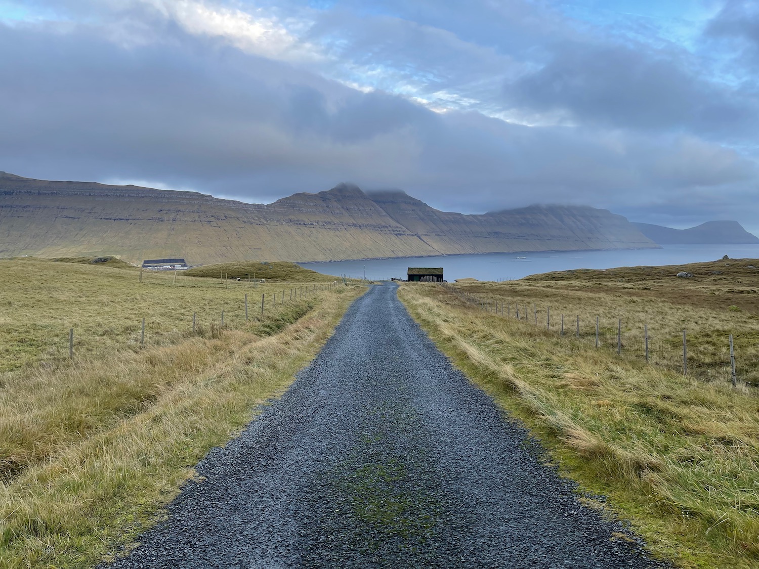 a gravel road leading to a body of water