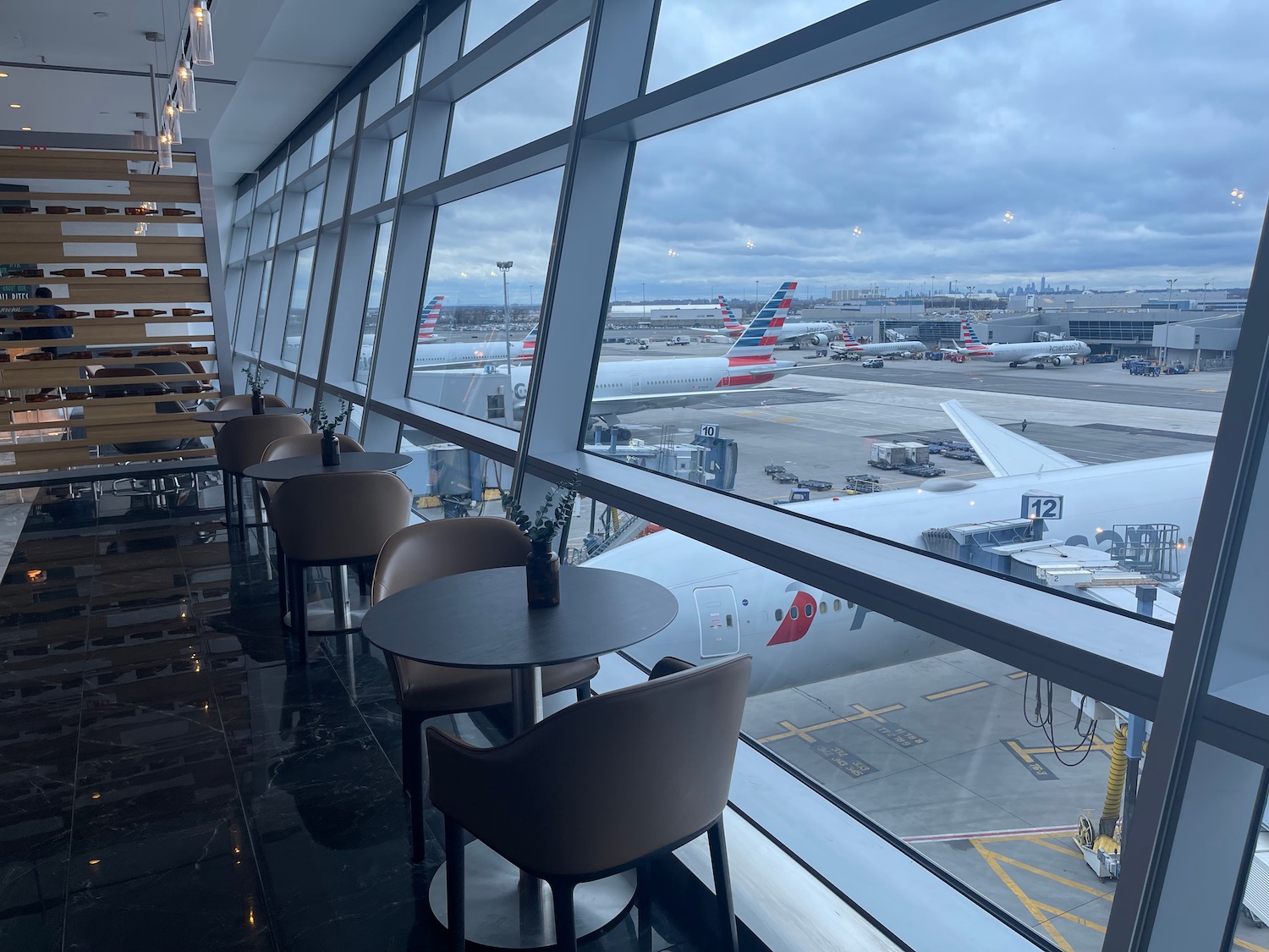 a window with tables and chairs in a building with planes in the background