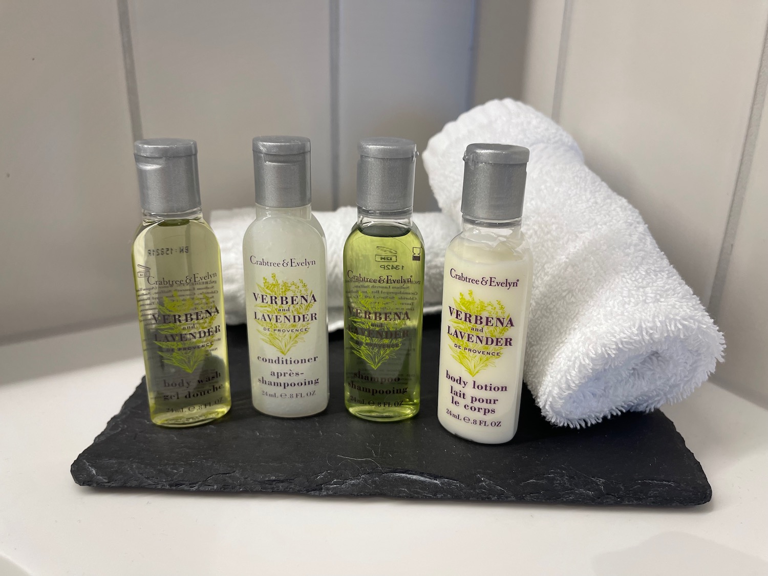 a group of small bottles of body lotion and a towel