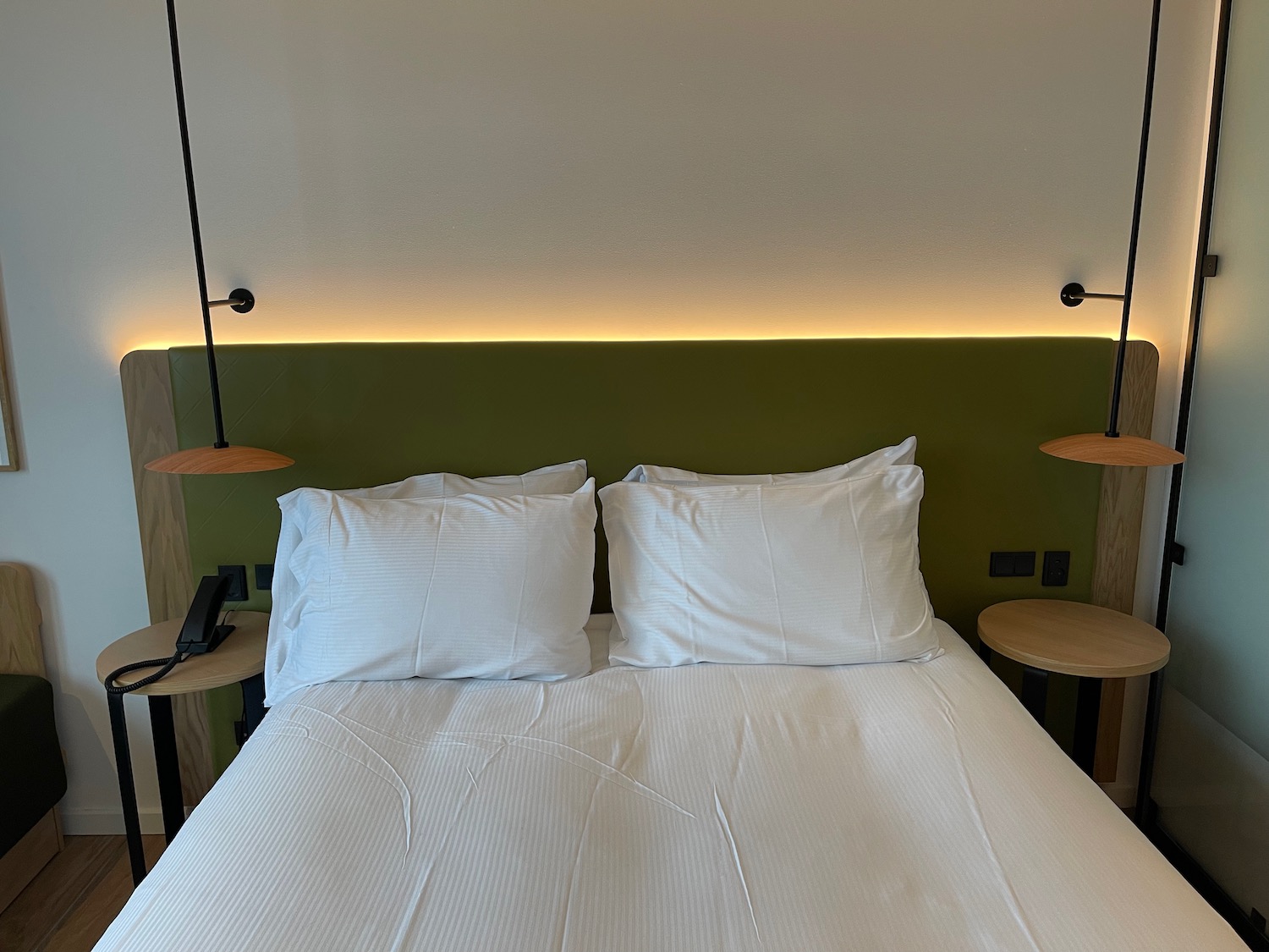 a bed with white sheets and two lamps