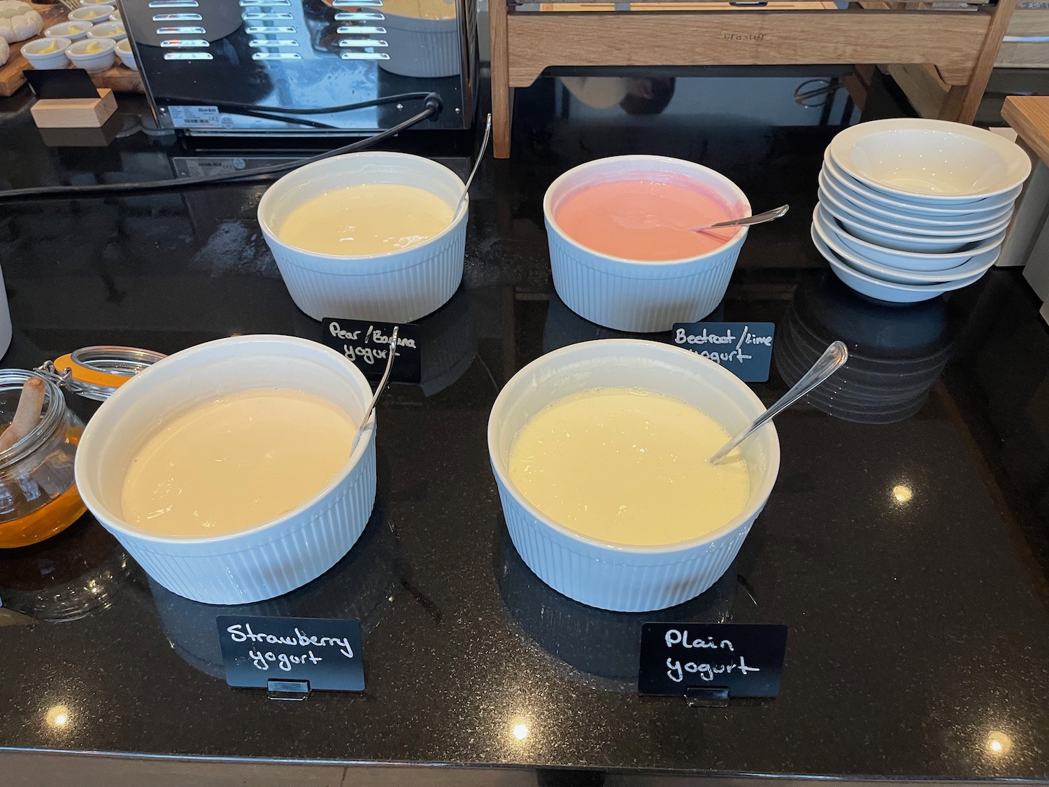 a group of bowls of yogurt with spoons