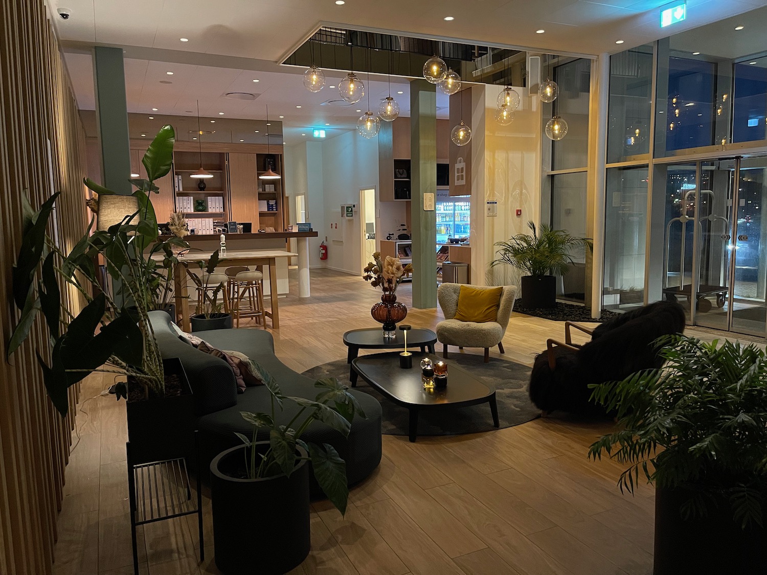 a room with a large glass wall and a large table with chairs and a plant