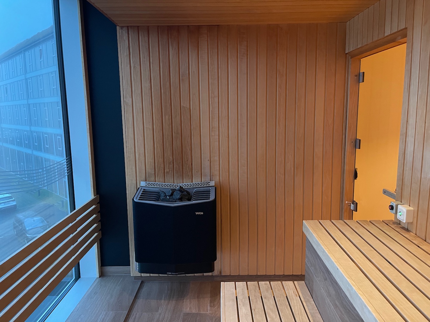 a sauna with a bench and a black object