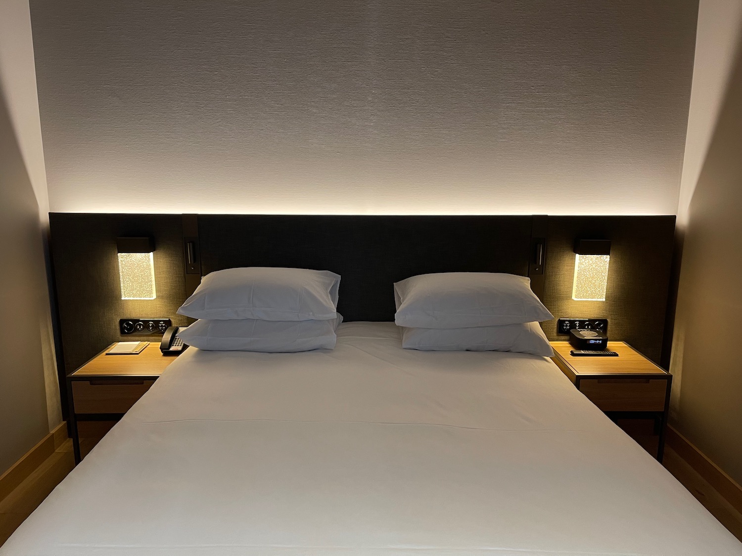 a bed with white sheets and pillows