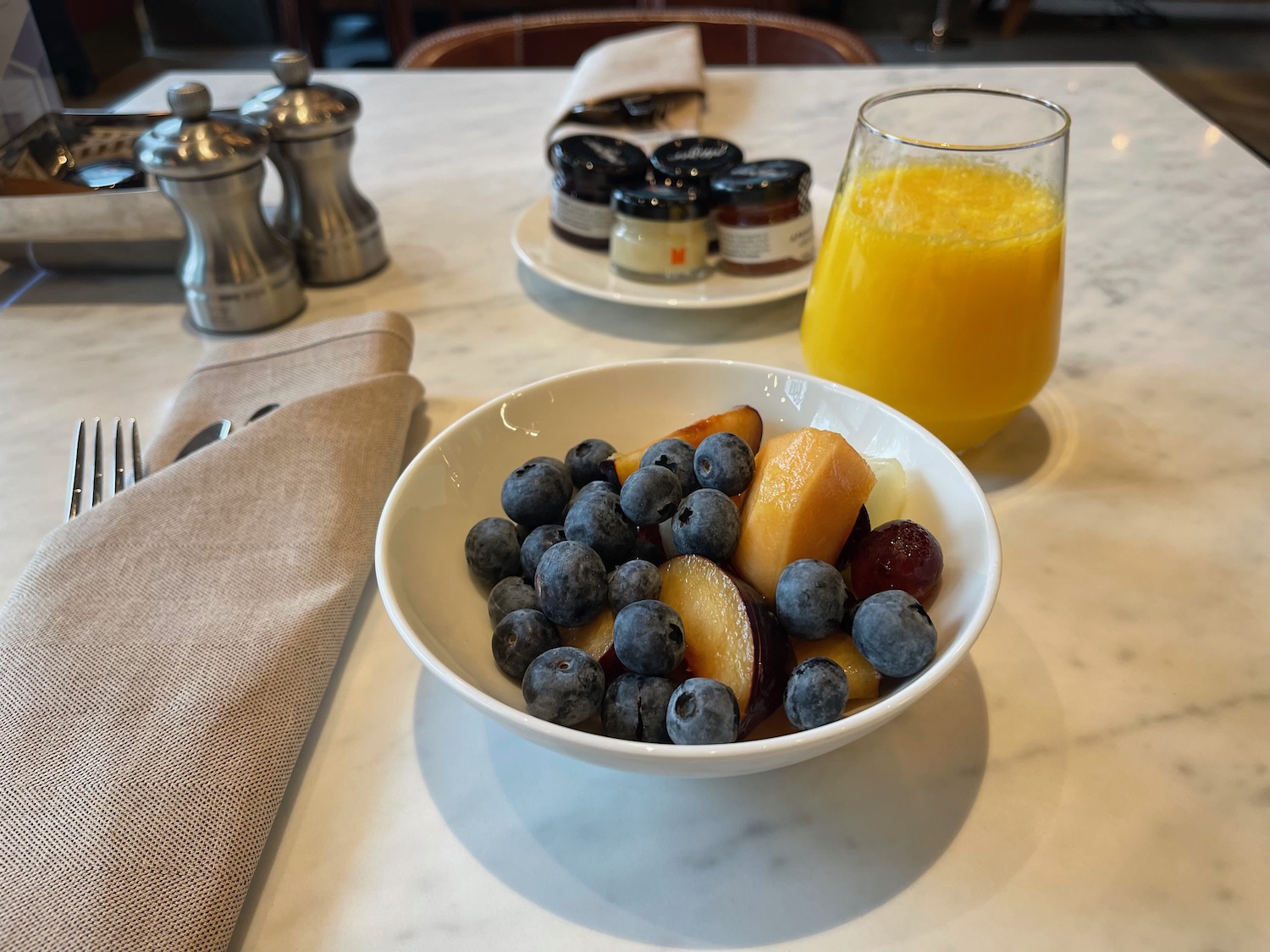 a bowl of fruit and a glass of orange juice