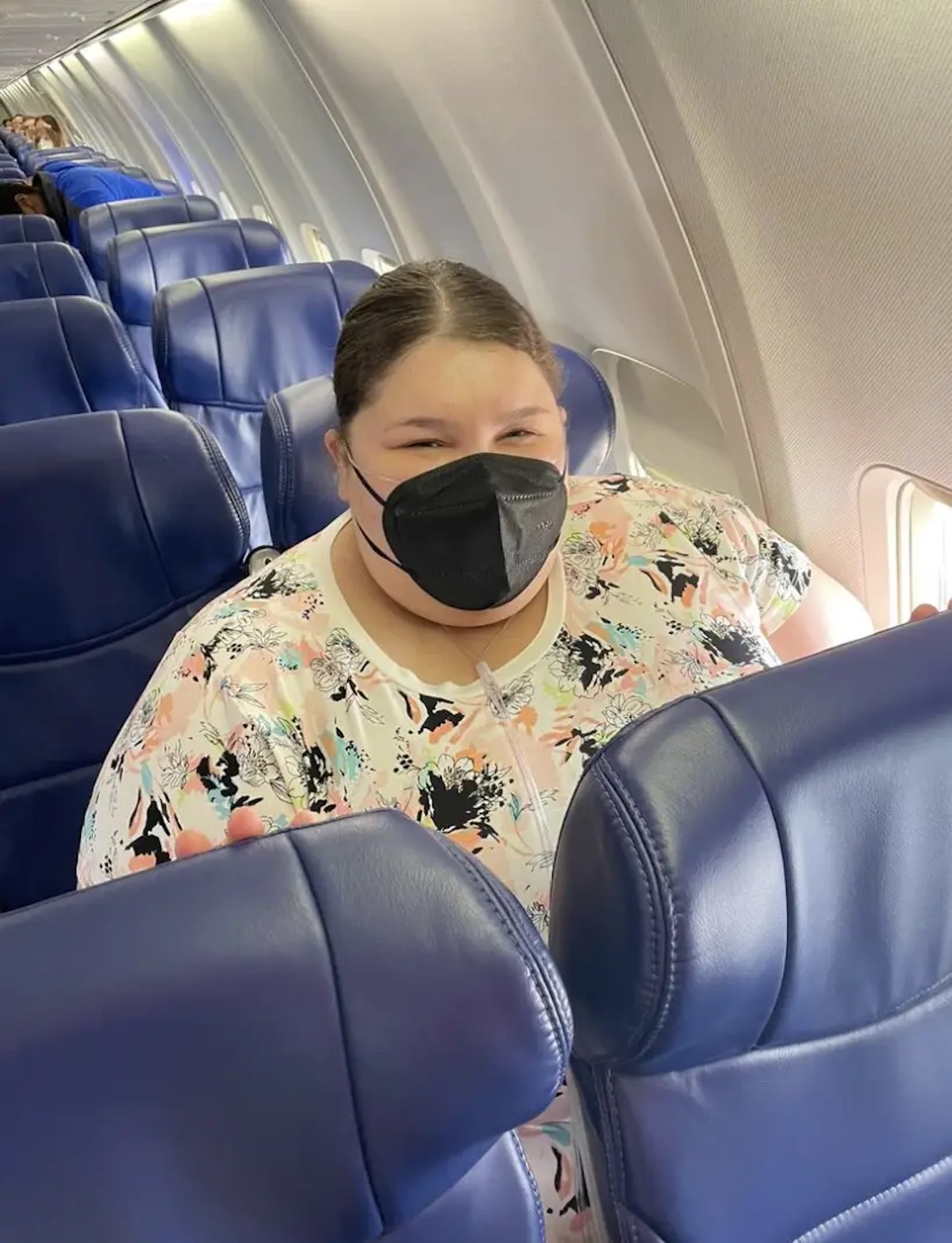 a woman wearing a face mask on an airplane