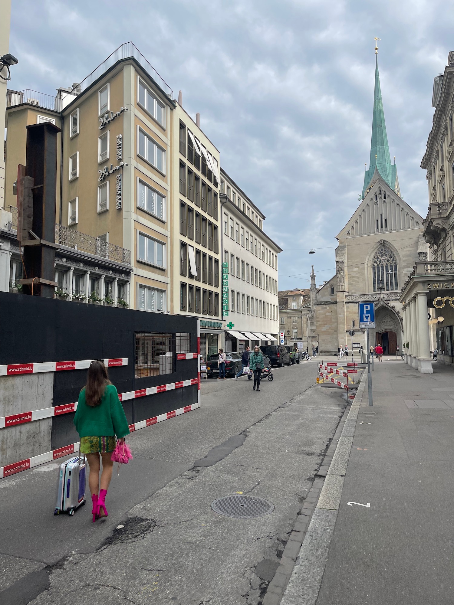 a woman walking down a street with luggage