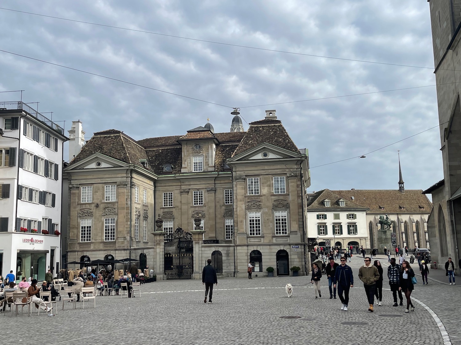 a group of people walking in a square with a building in the background